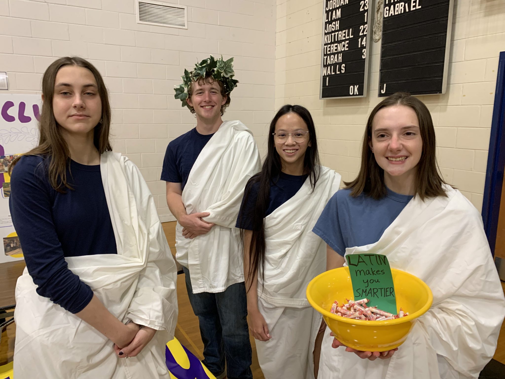 Four Latin Club members wearing togas pose for a photo