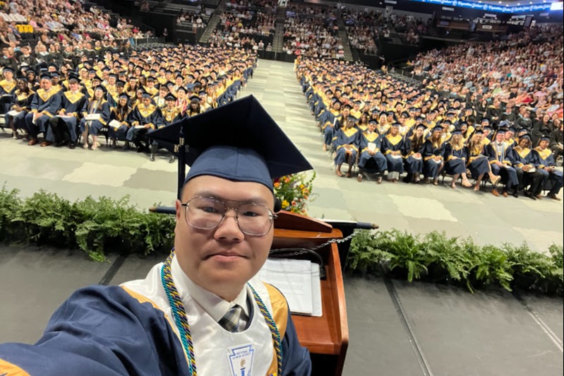 Graduate selfie in front of graduating class