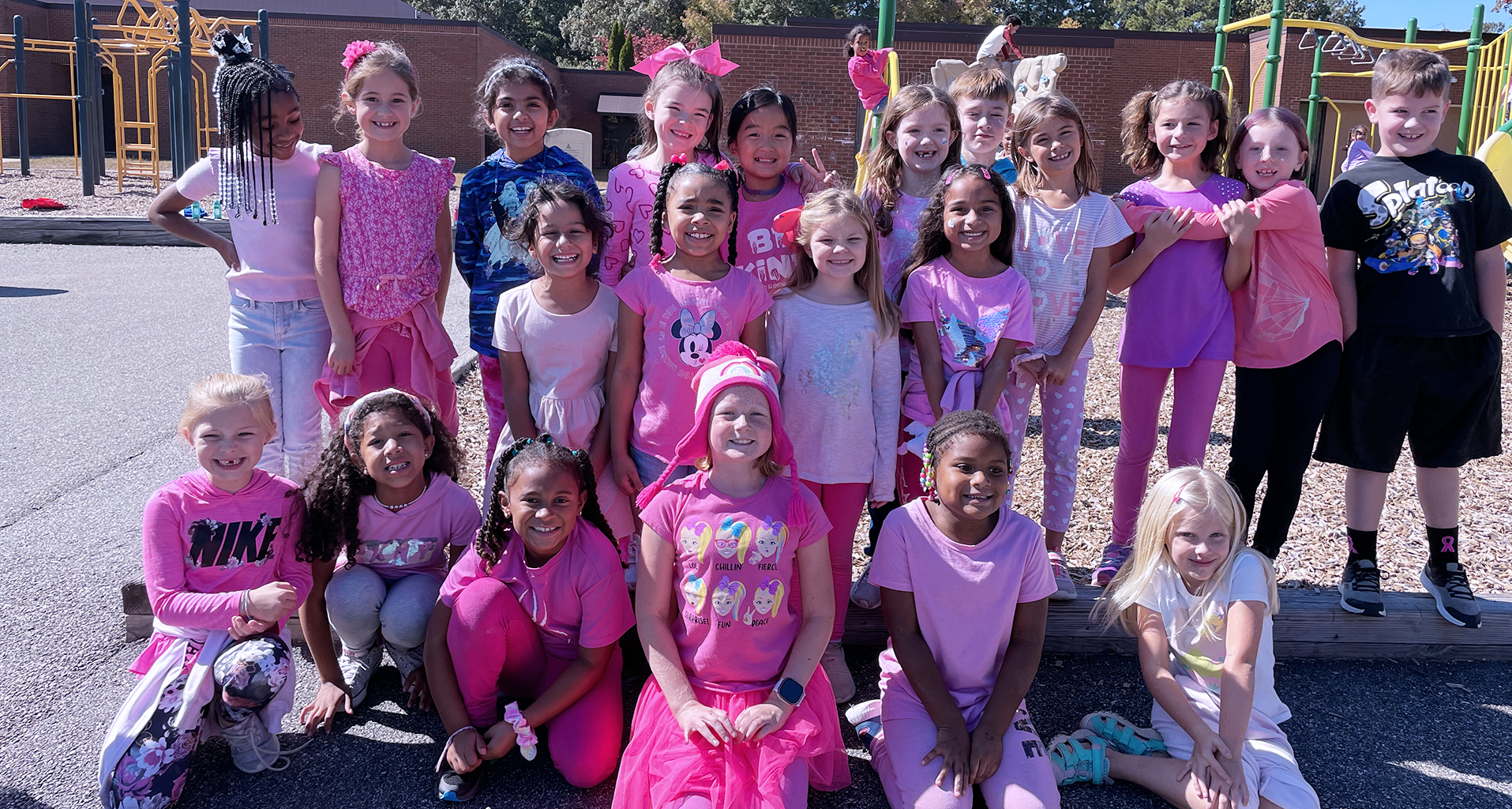 Large group of female students dressed all in pink.