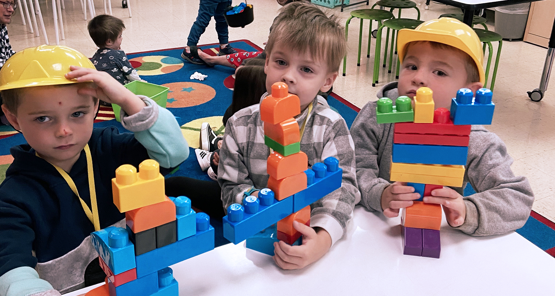 three boys building with blocks