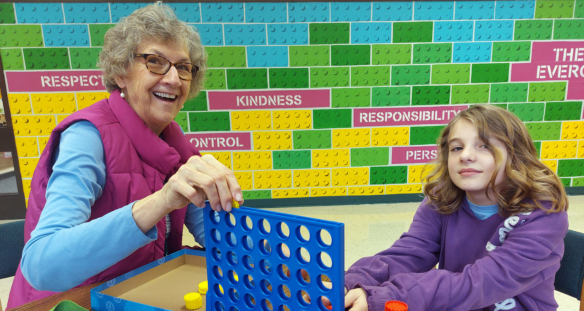 Female volunteer plays a game with a female student.