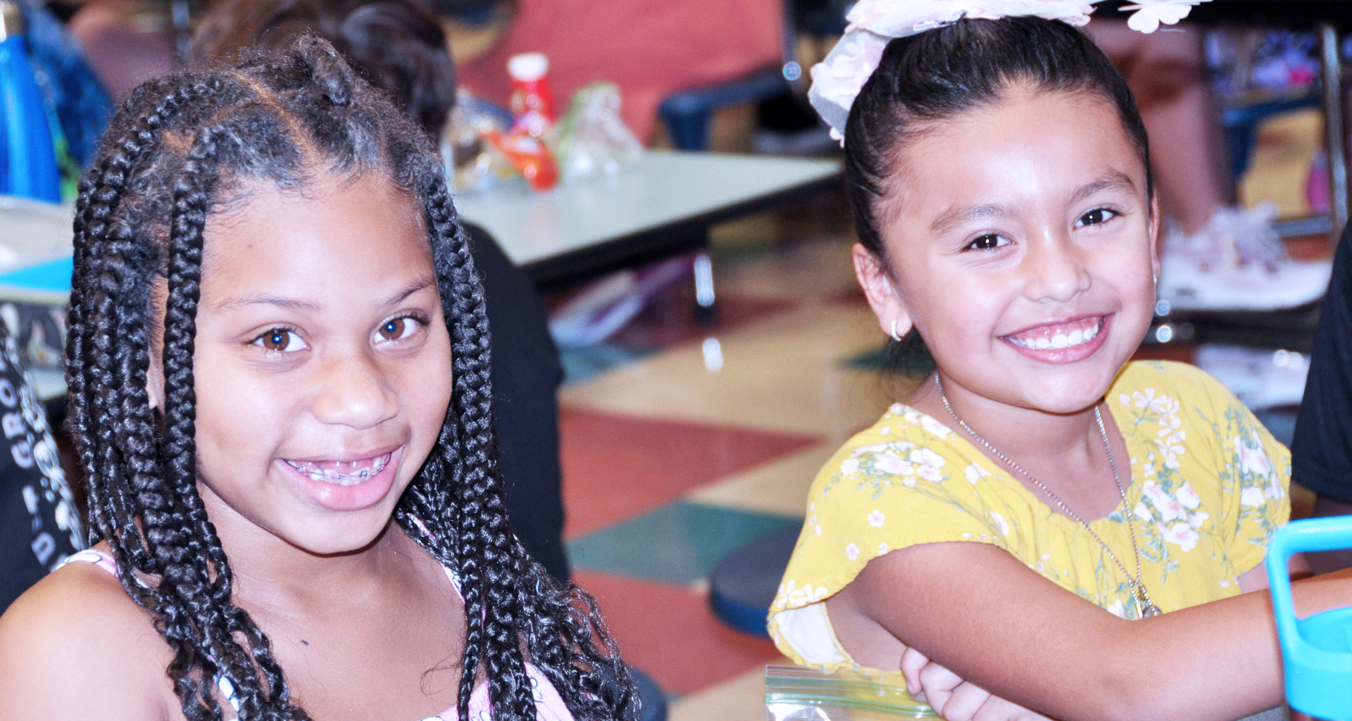 Two girls smiling in the school cafeteria