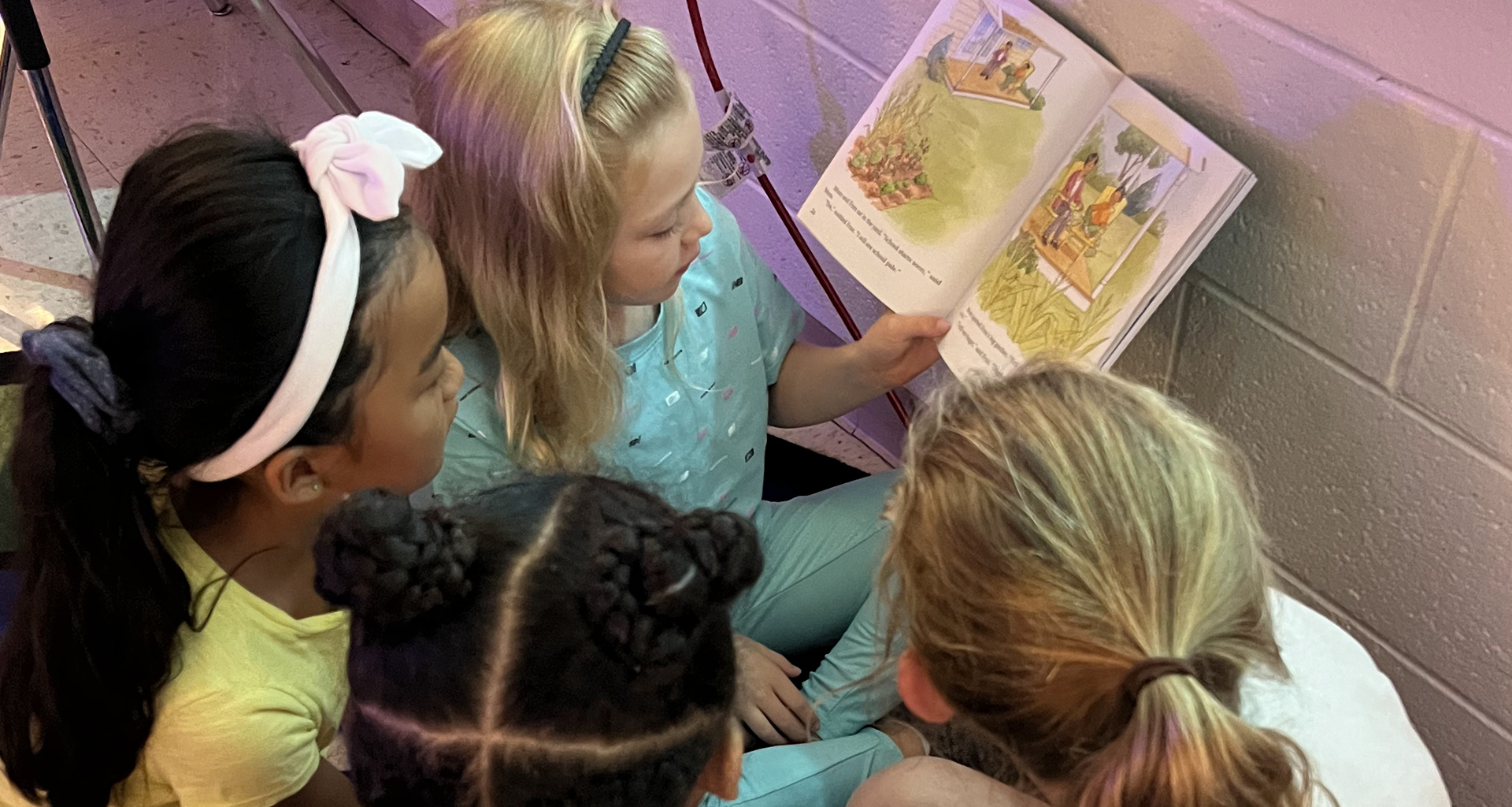 Four students reading a book together