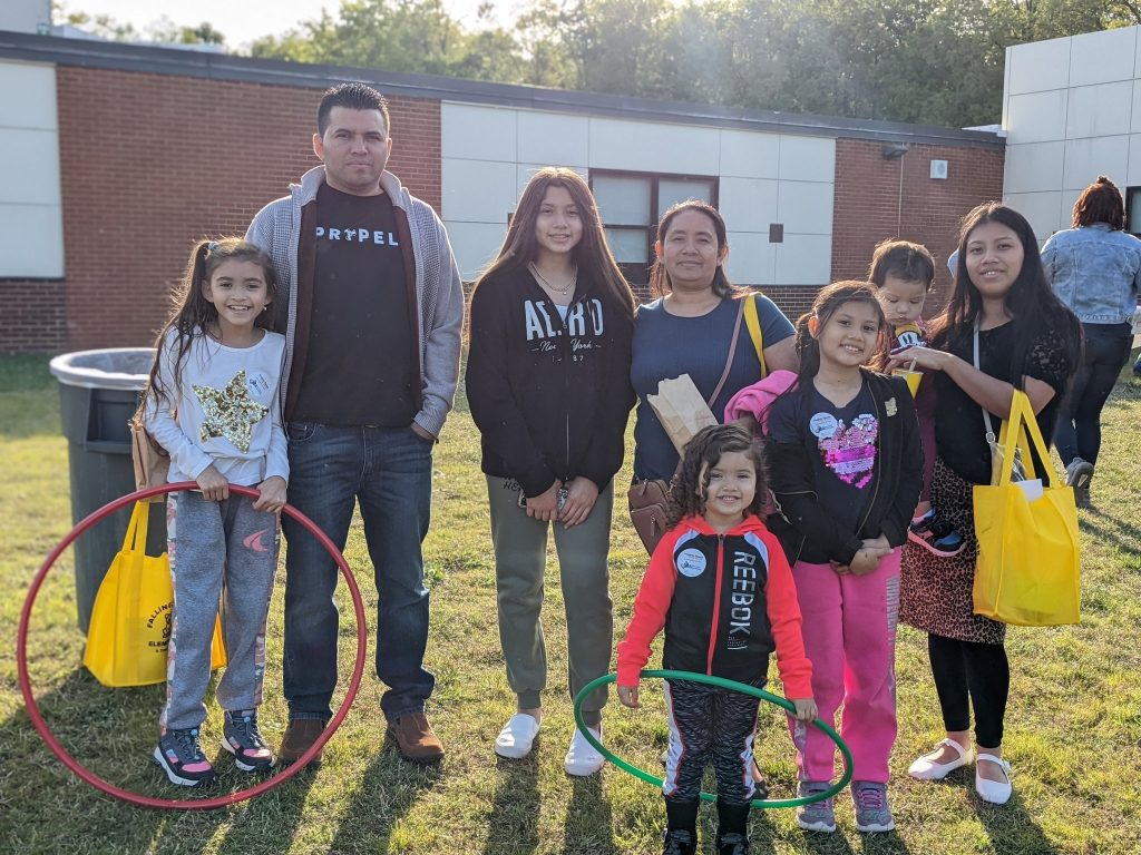 A family standing together outside of the school