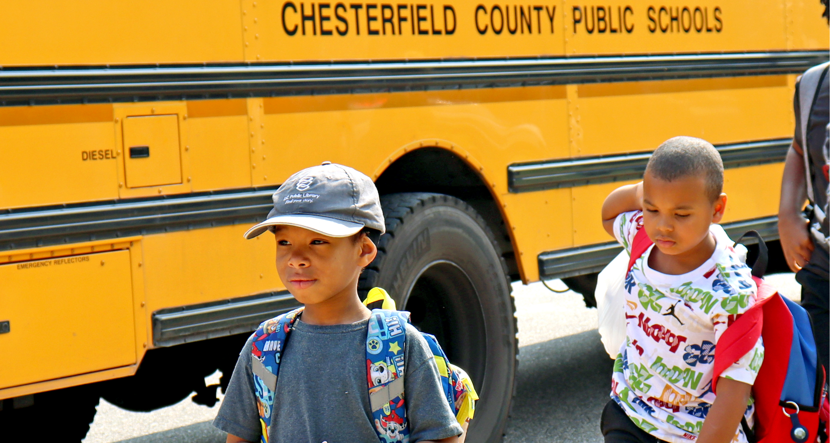 Two students walking away from their school bus