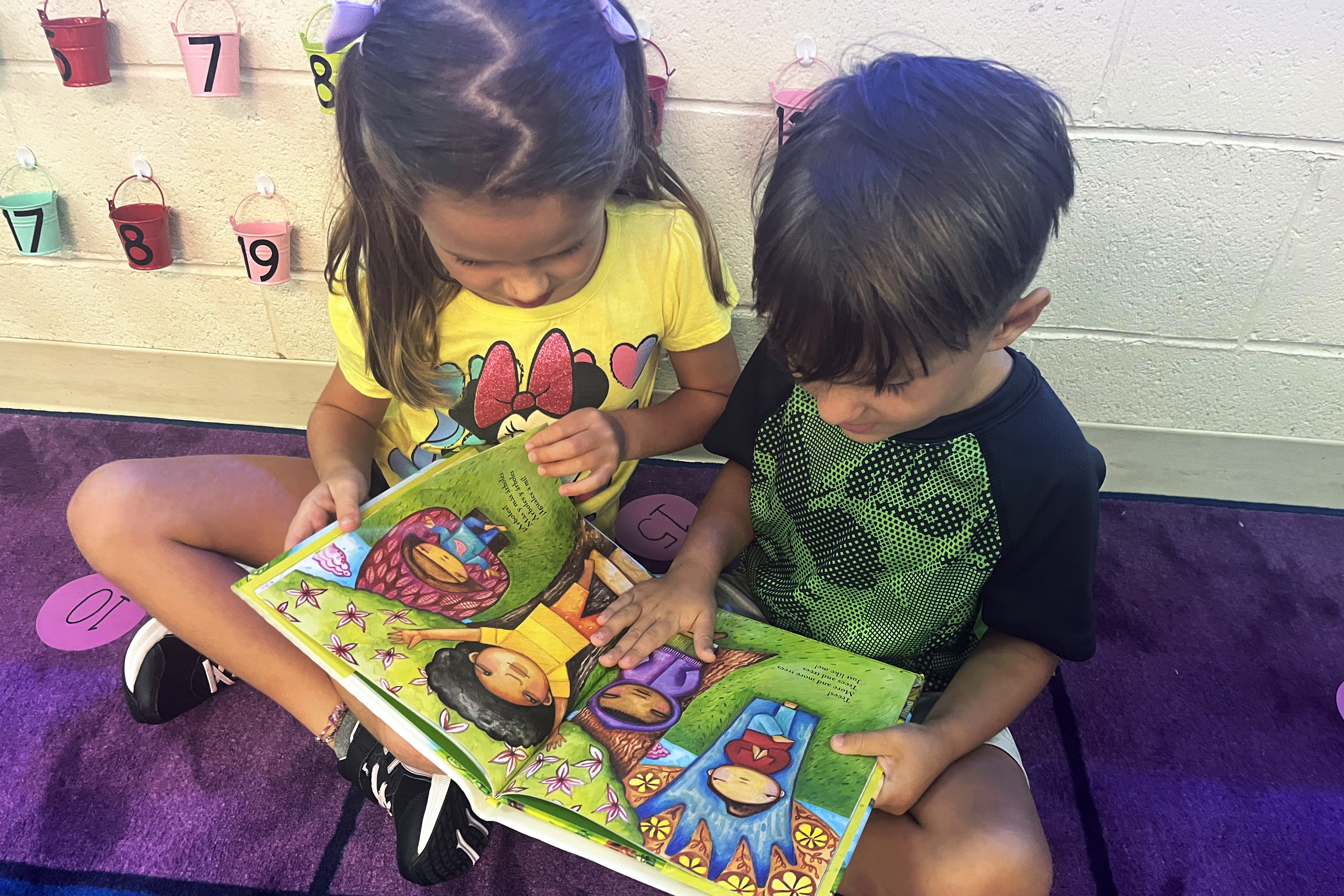Two young students reading a book.