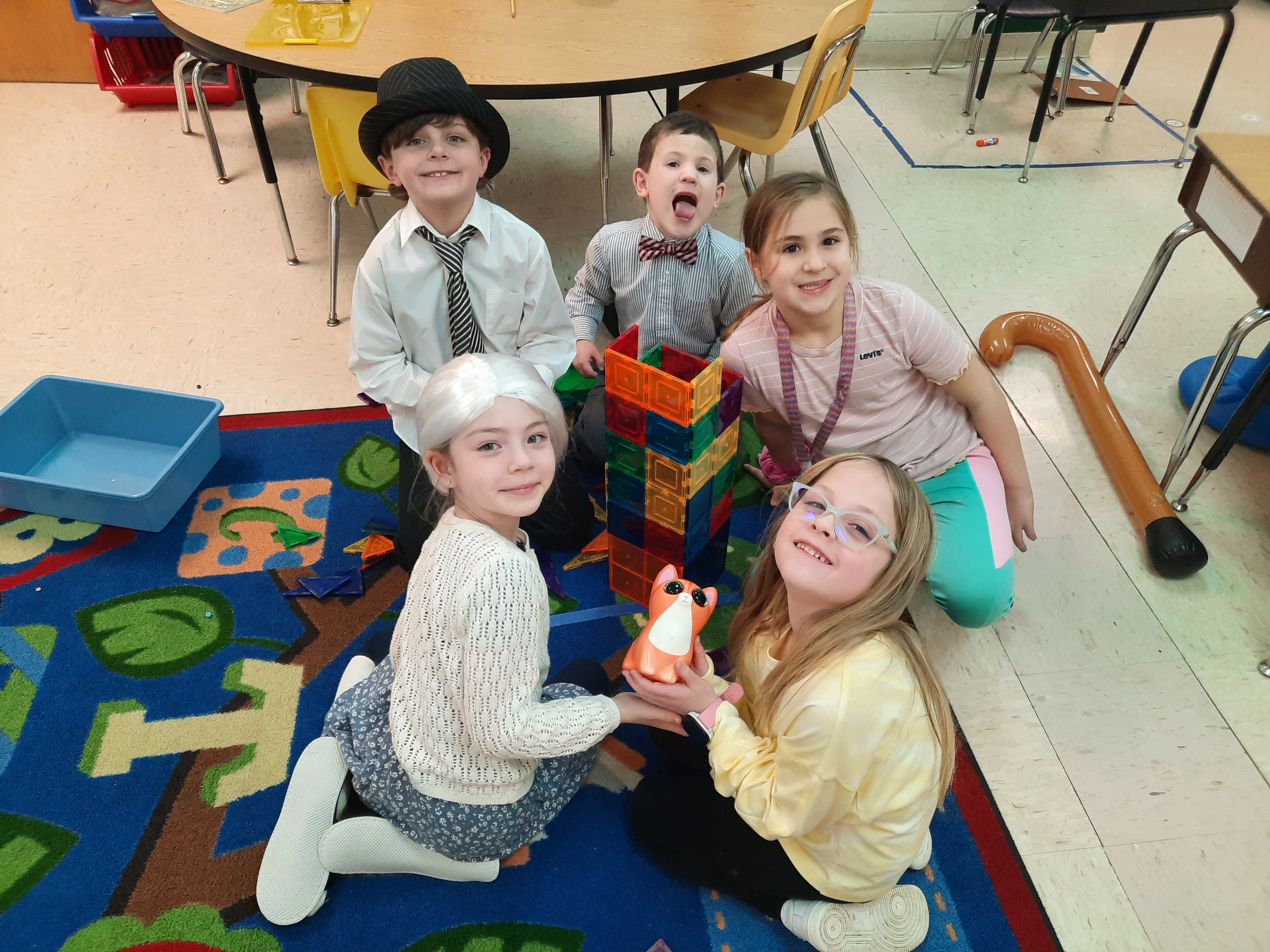 Five students building a tower with blocks.
