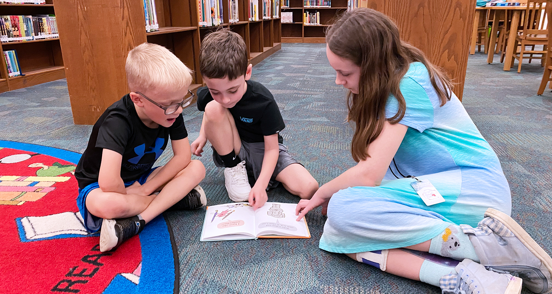 Three  students reading a book together.