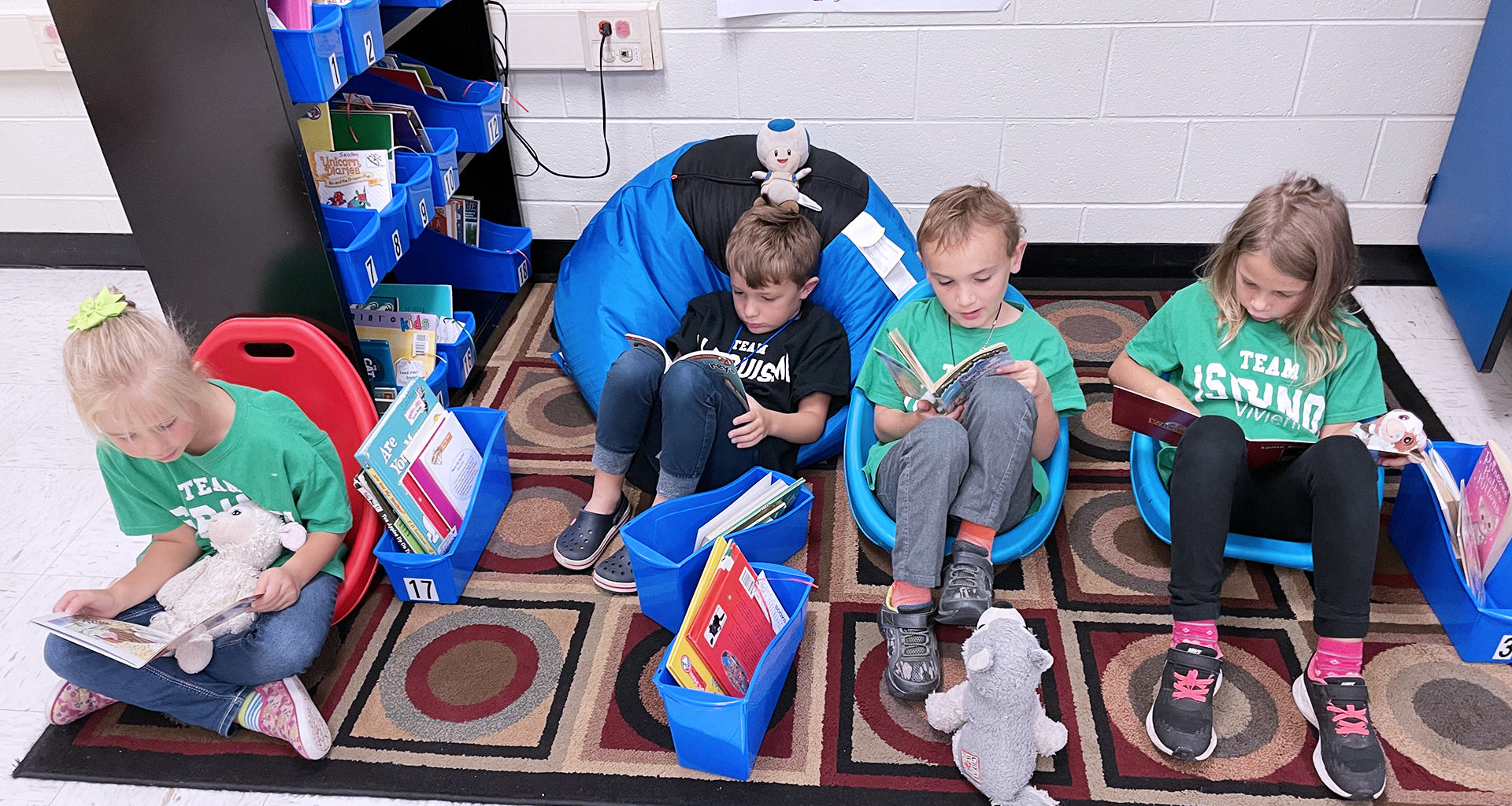 Four students sitting on the floor reading.