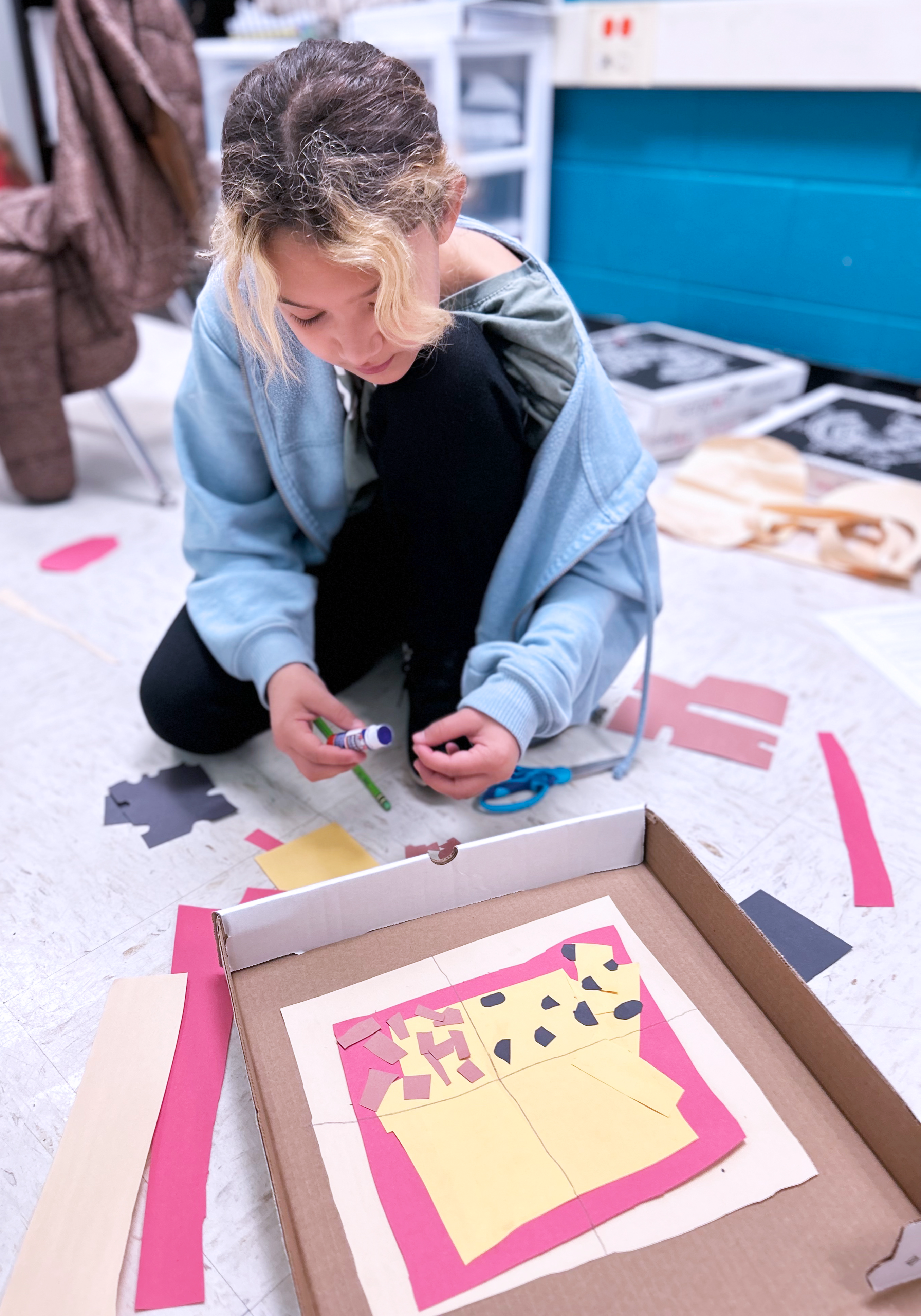 Female student working on a project on the floor.