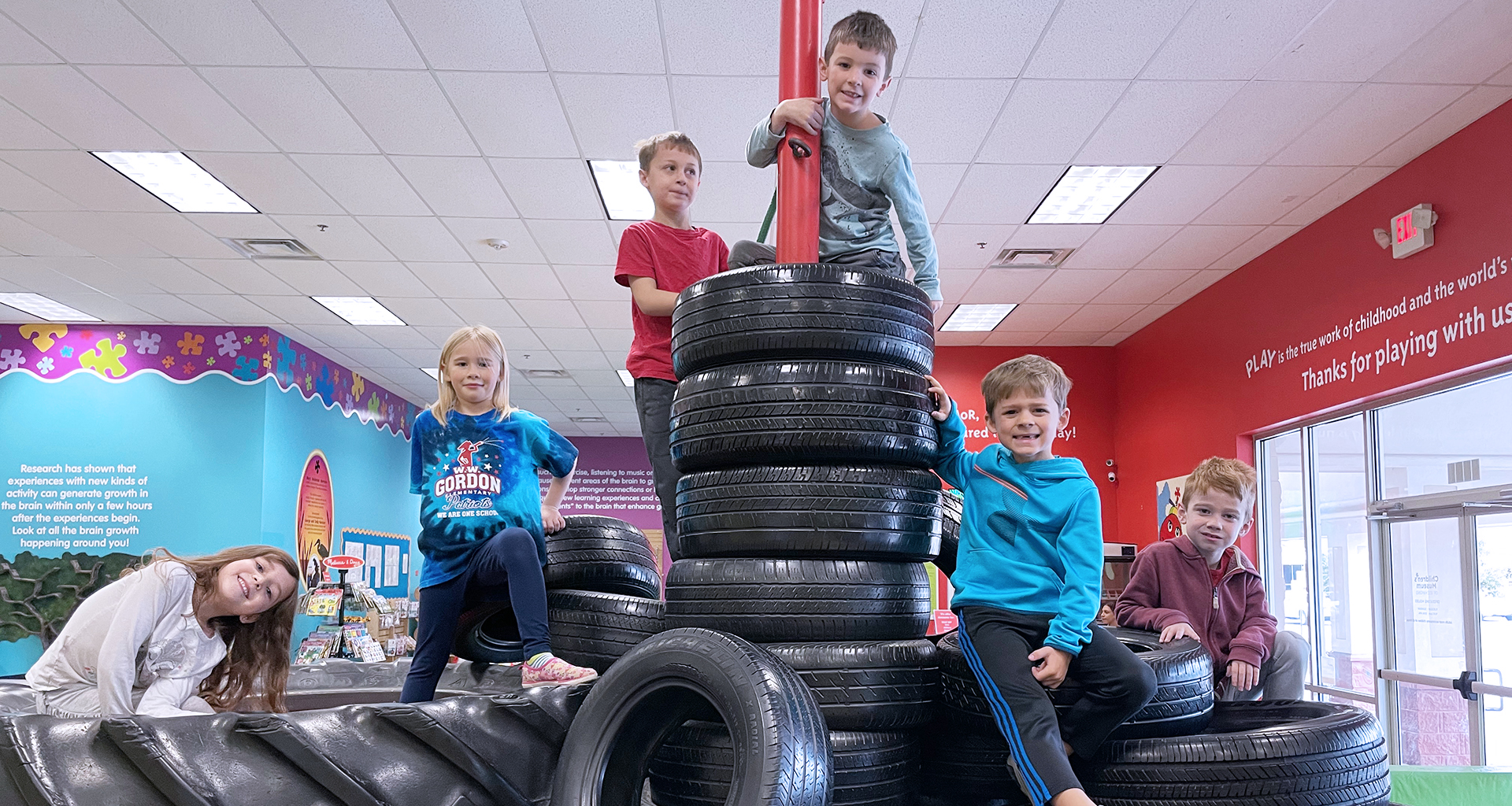 Students climb a giant pile of tires.