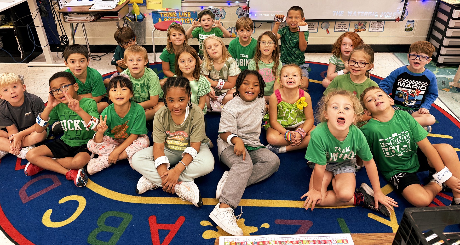 students sitting on the floor pose for a photo