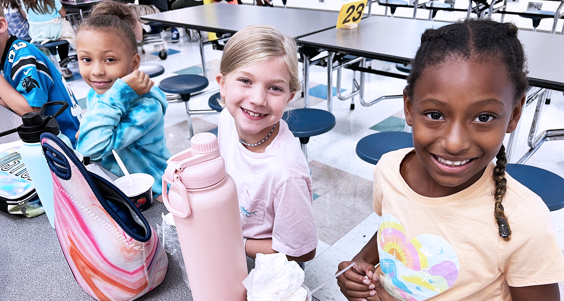 Three students eating lunch at the school cafeteria