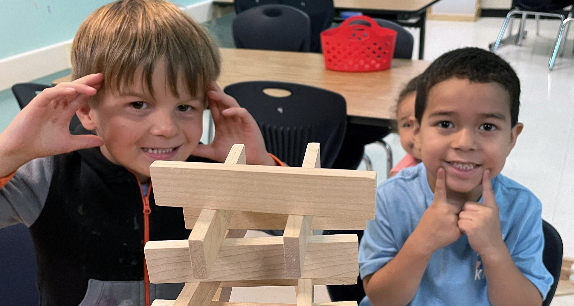 Two students building a tower with blocks