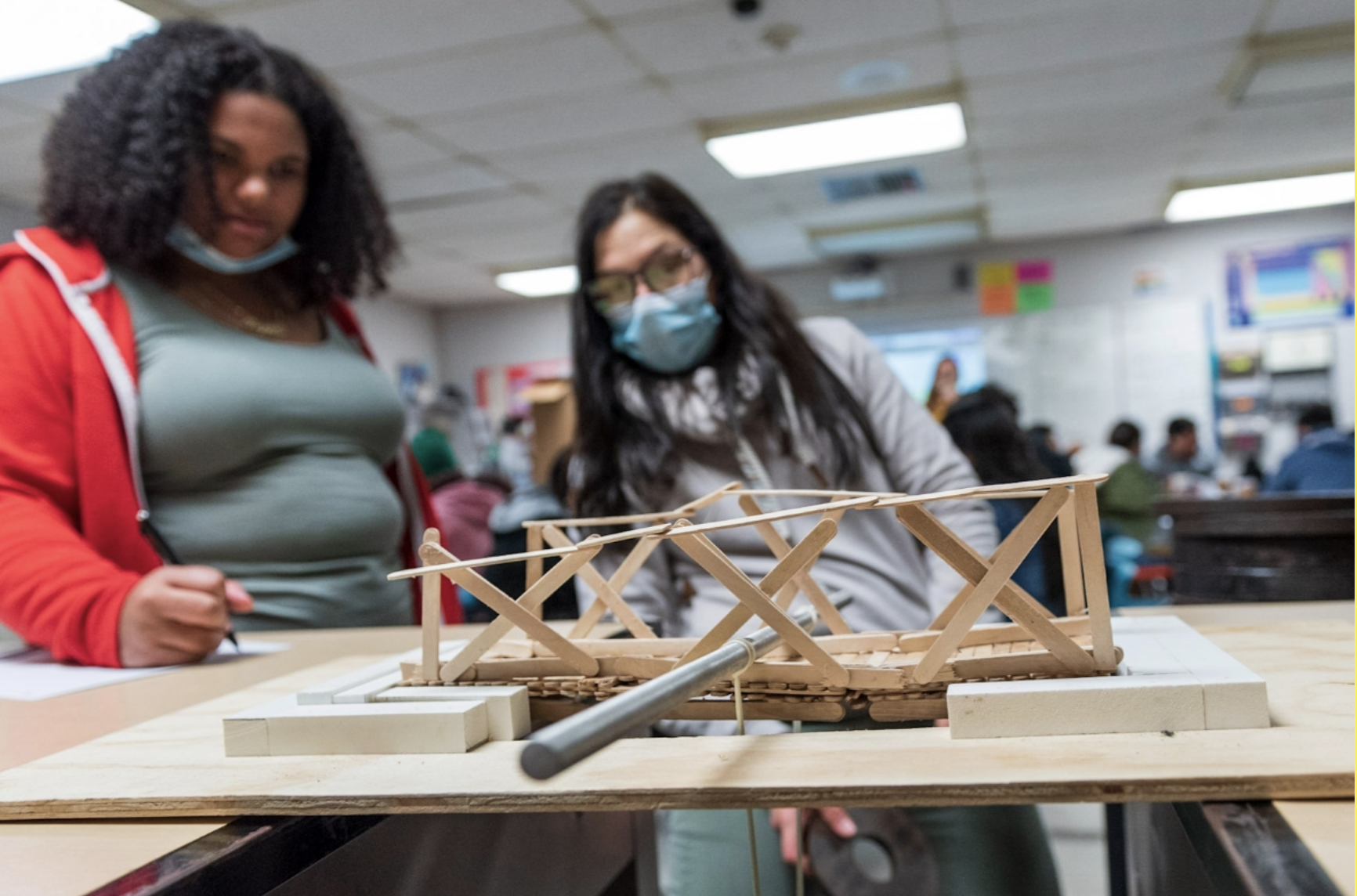 two female students working on a wooden craft project