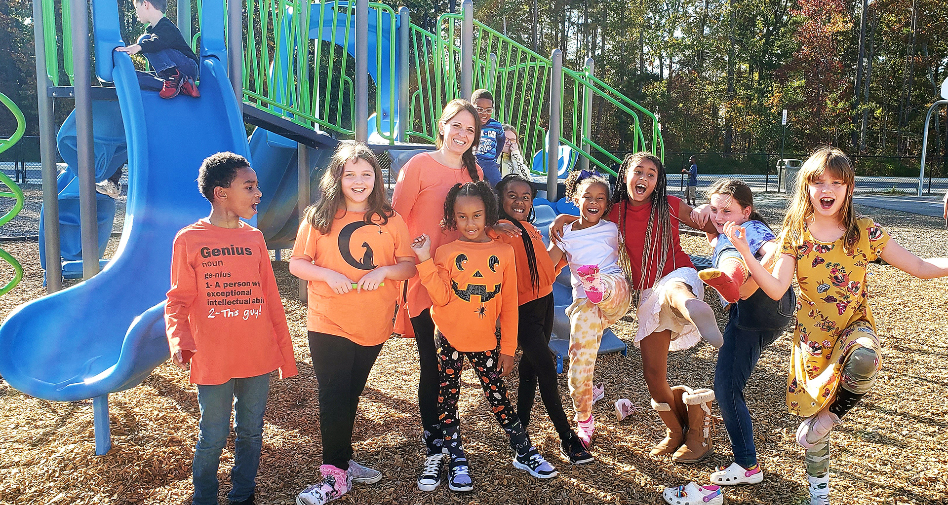 Group of students pose in a silly manner on the playground.