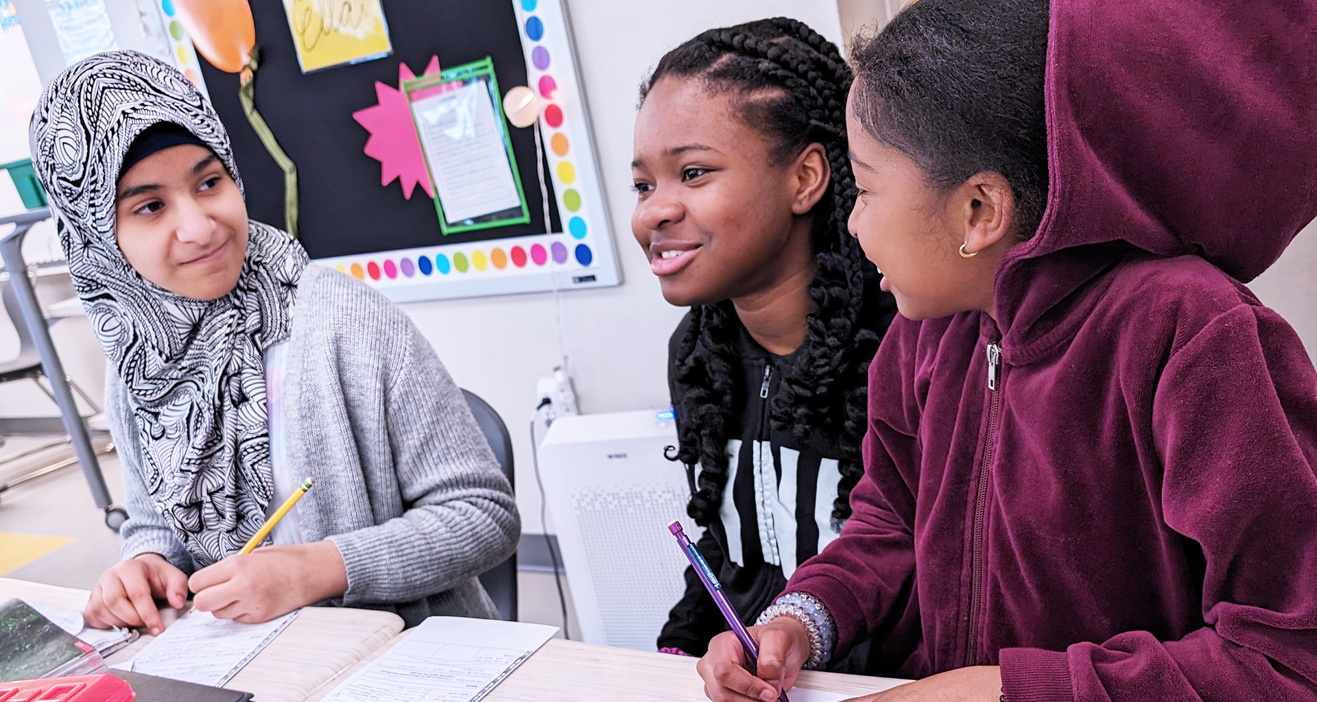 Three students working together in the classroom