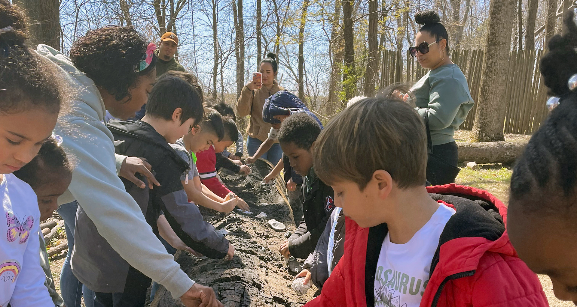 Students outside on a field trip digging for fossils.