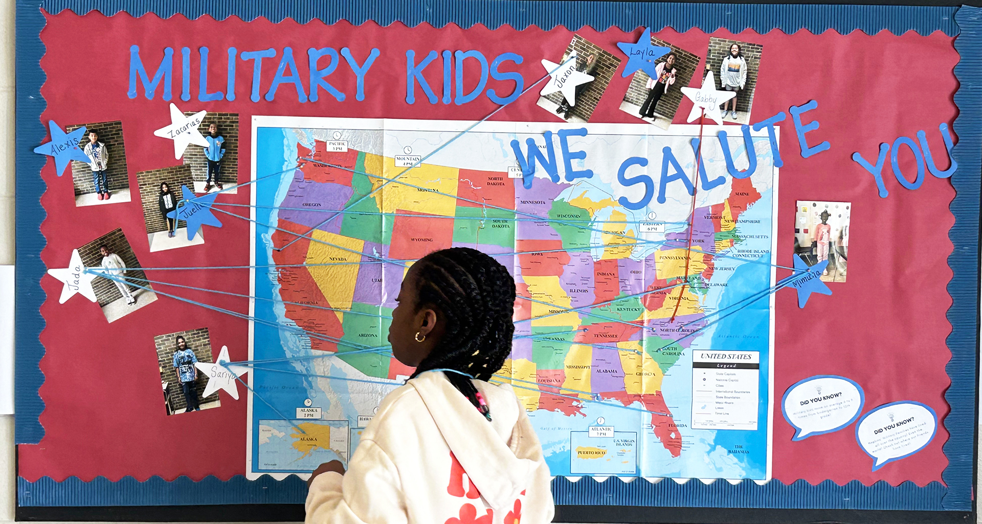 student looking at wall decorated with military kids salute