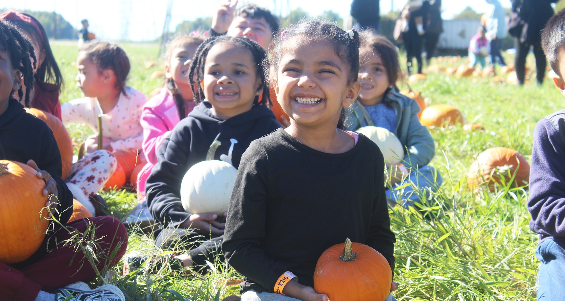 Students outside holding their pumpkins from the pumpkin patch