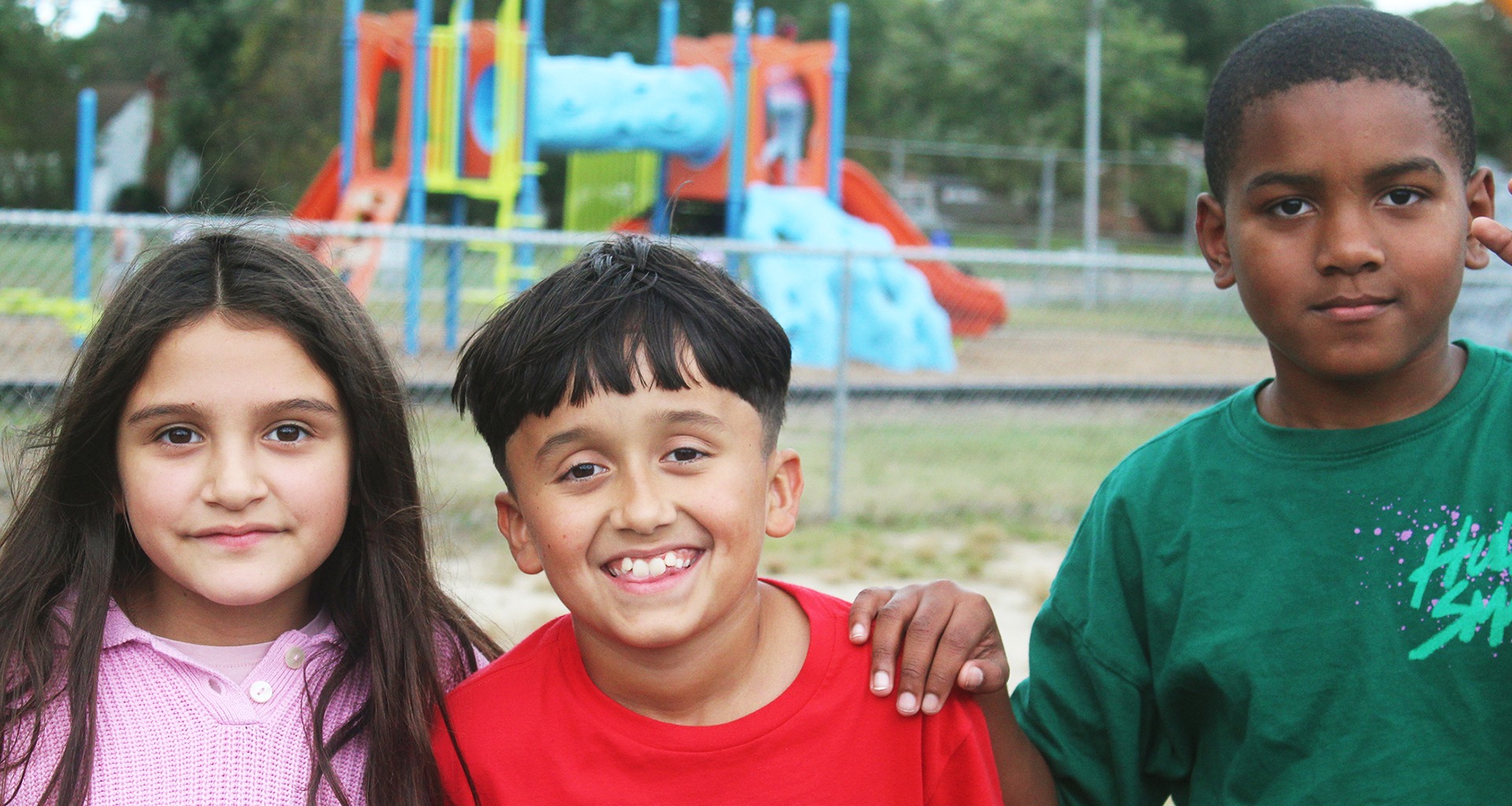 Three students smile for a photo