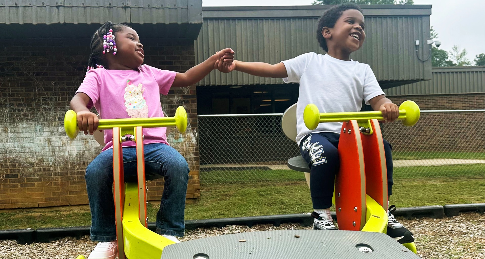 Two students bump fists on playground.