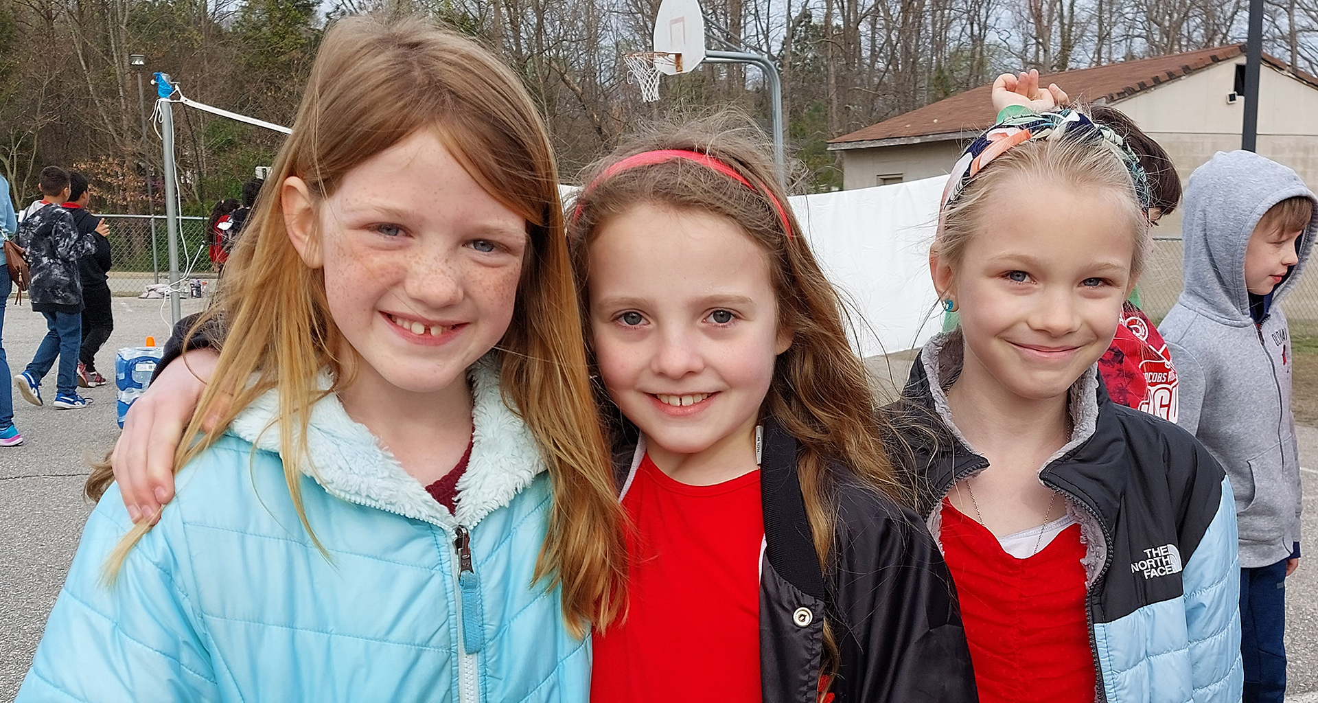 Three girls smiling outside