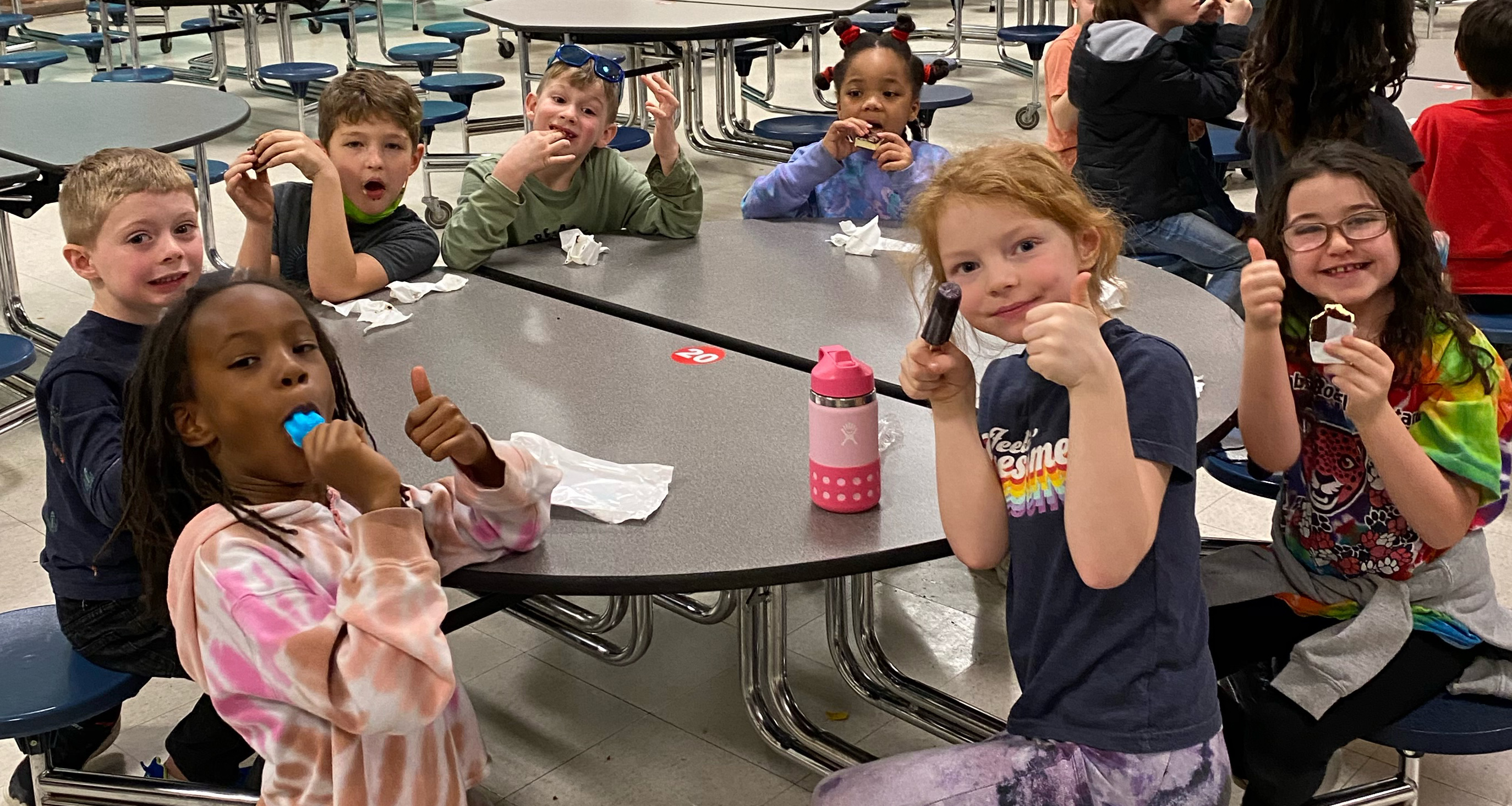 A group of students eating ice cream in the school cafeteria