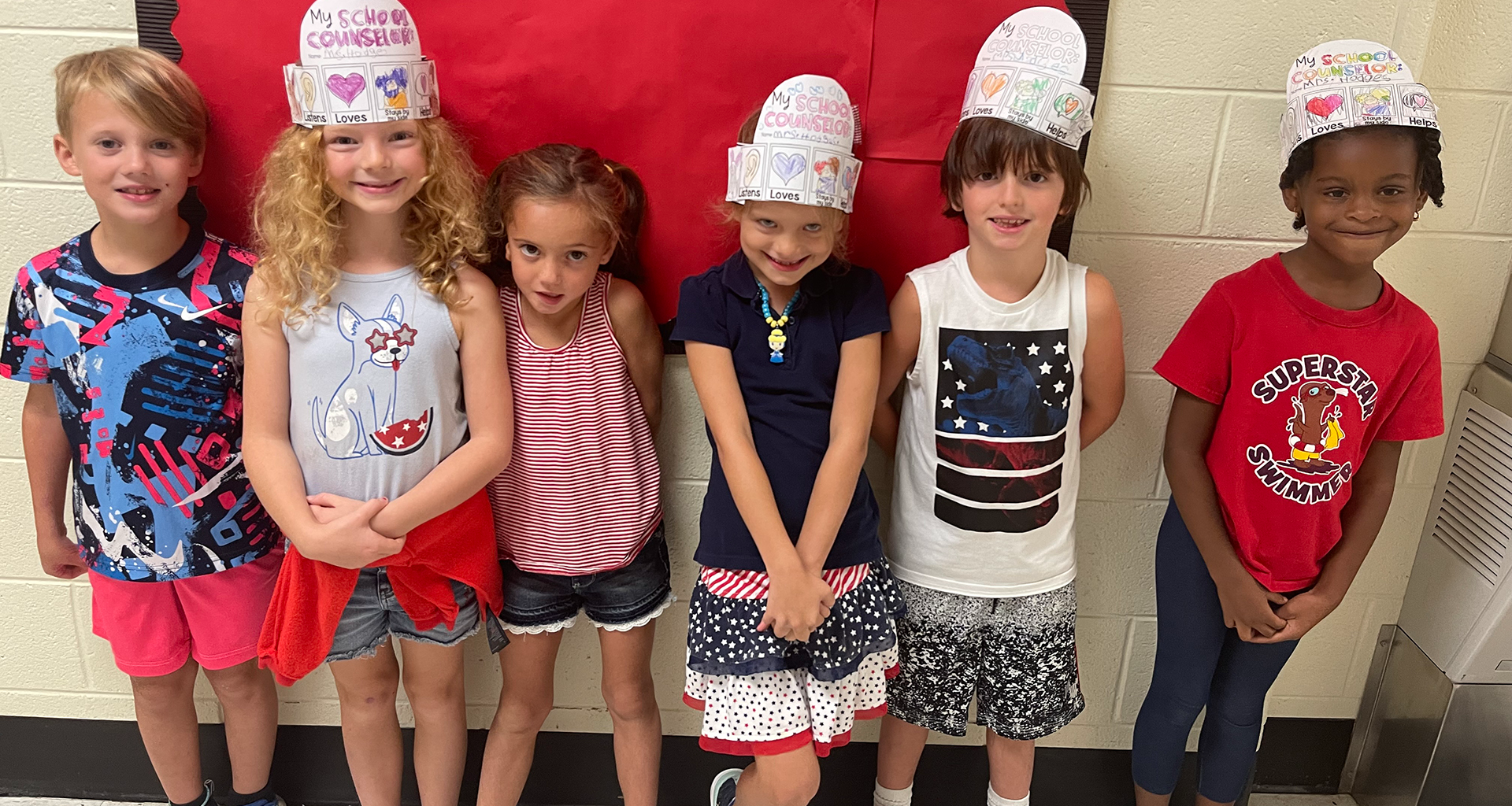 Group of students pose with their homemade hats