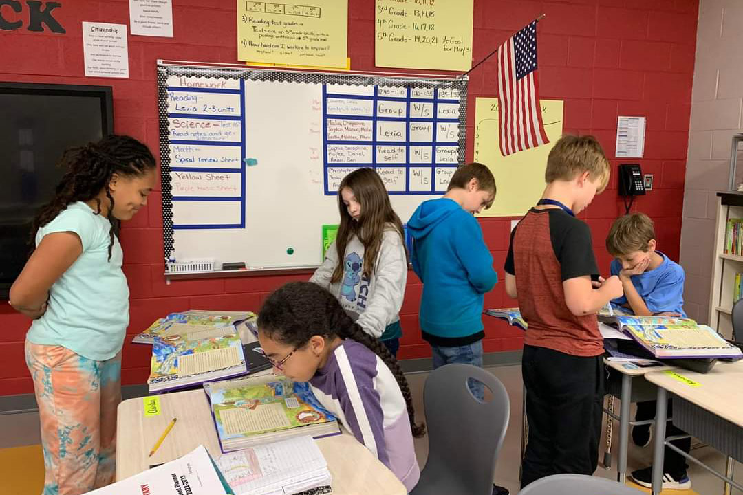 A group of students reading a textbook in class