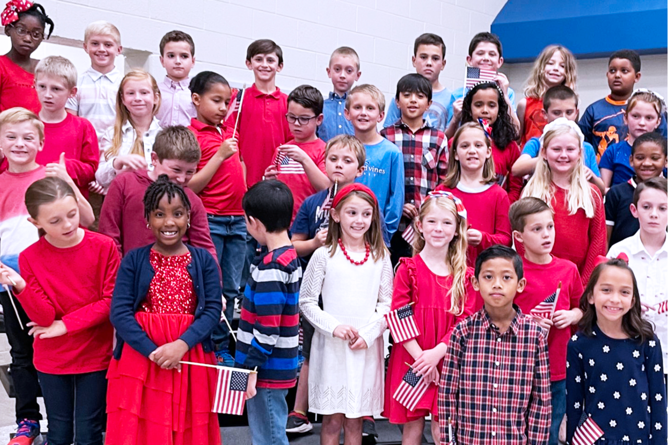 Class dressed in red white and blue pose for a photo.