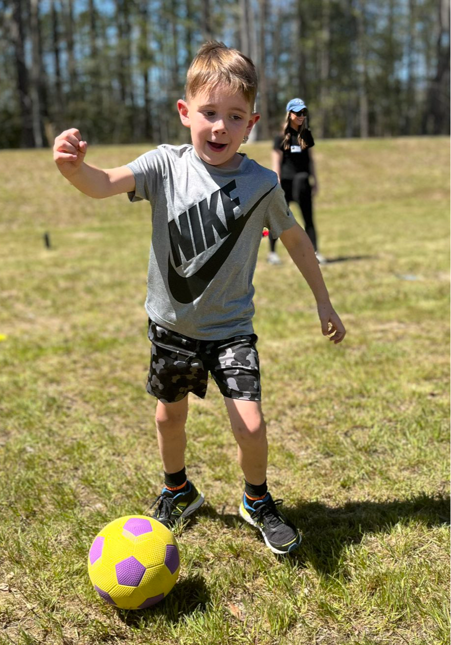 Young student kicking a soccer ball.