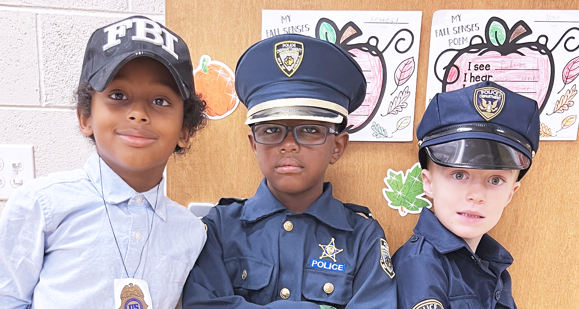 Three young male students pose in police and FBI outfits.