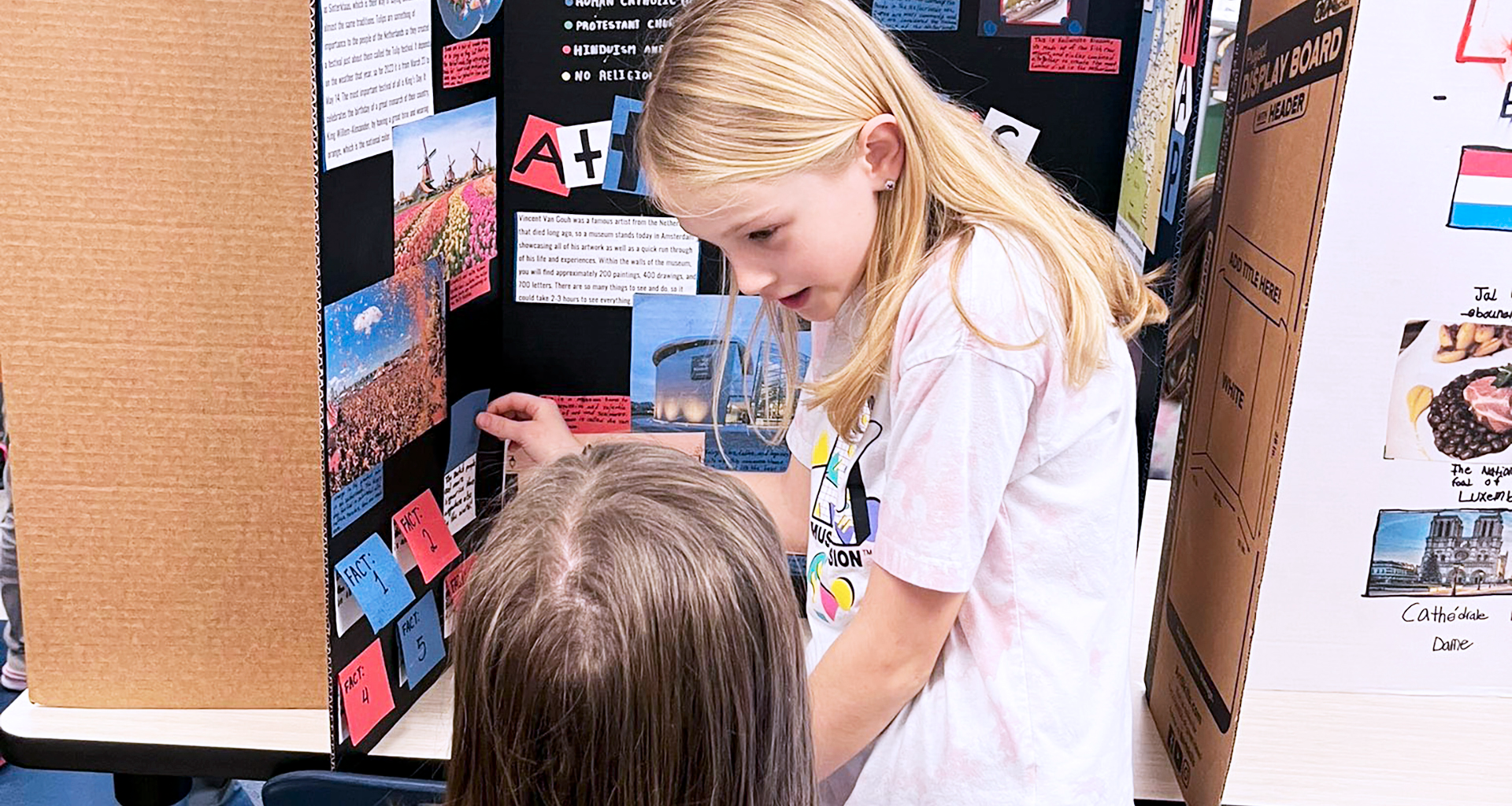 Two students looking at a poster together during a fair.