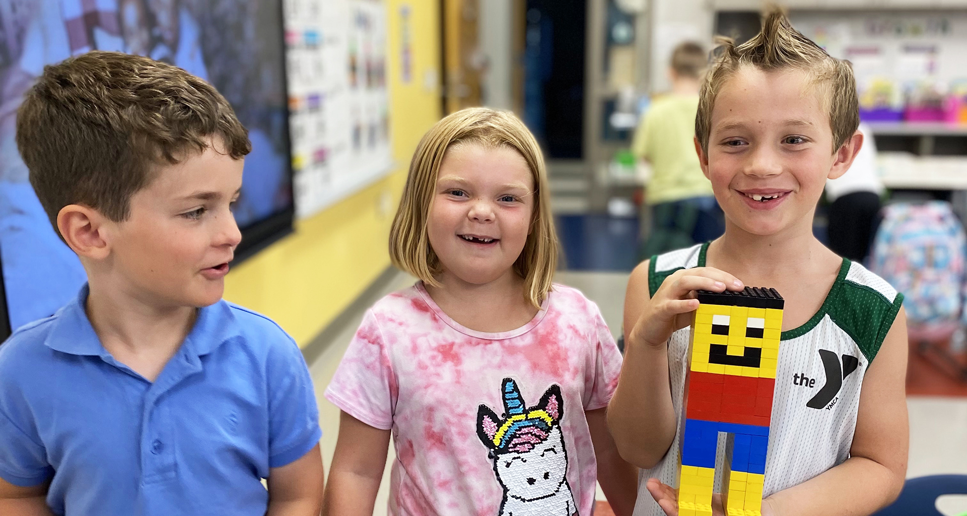 Three students show the block tower they made.