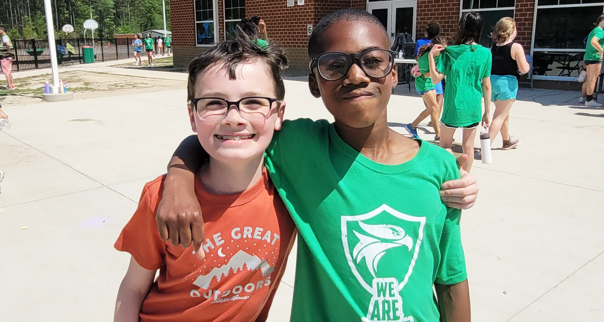 Two students doing a side hug pose for a photo