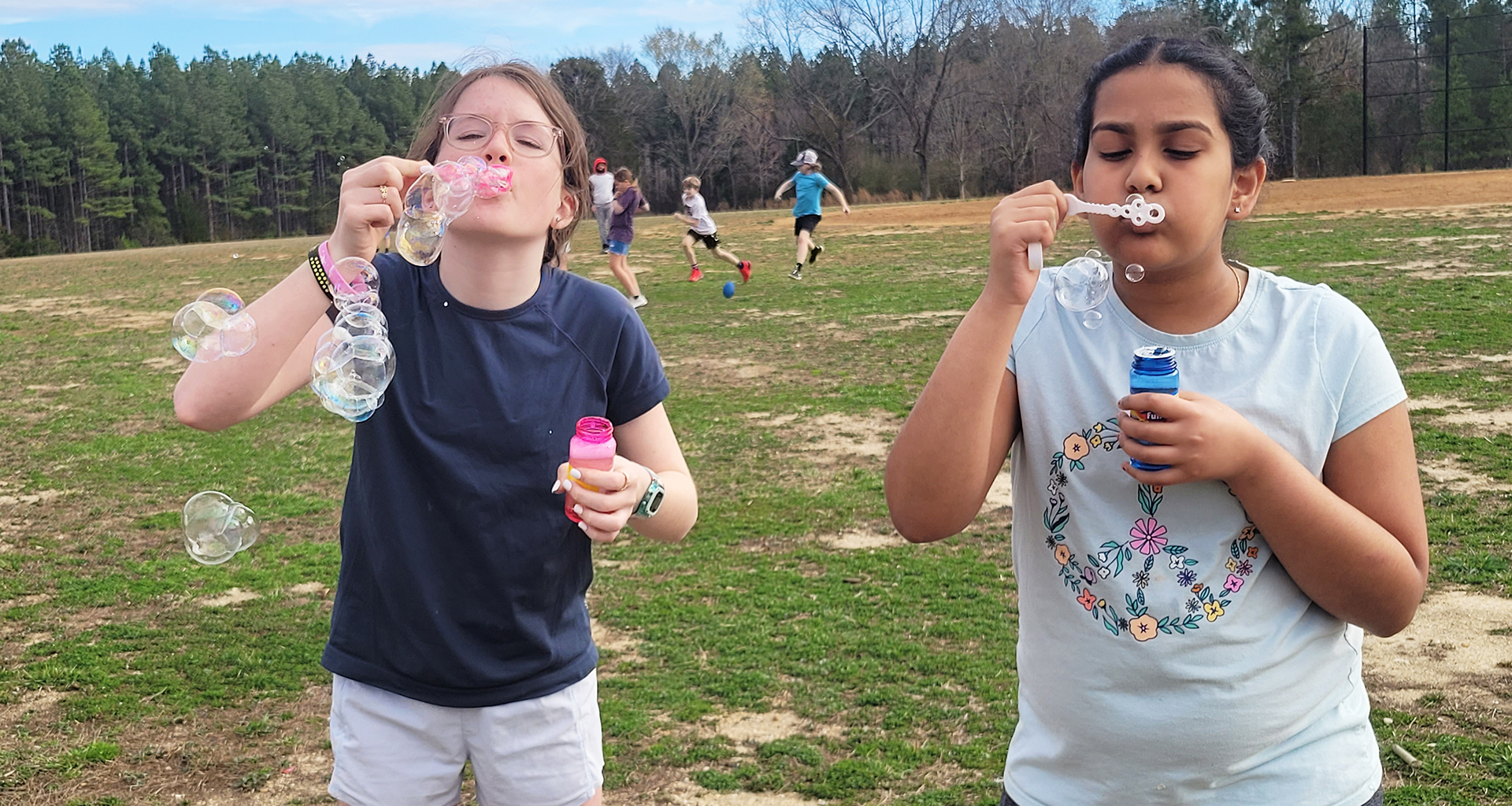 Two female students blowing bubbles.