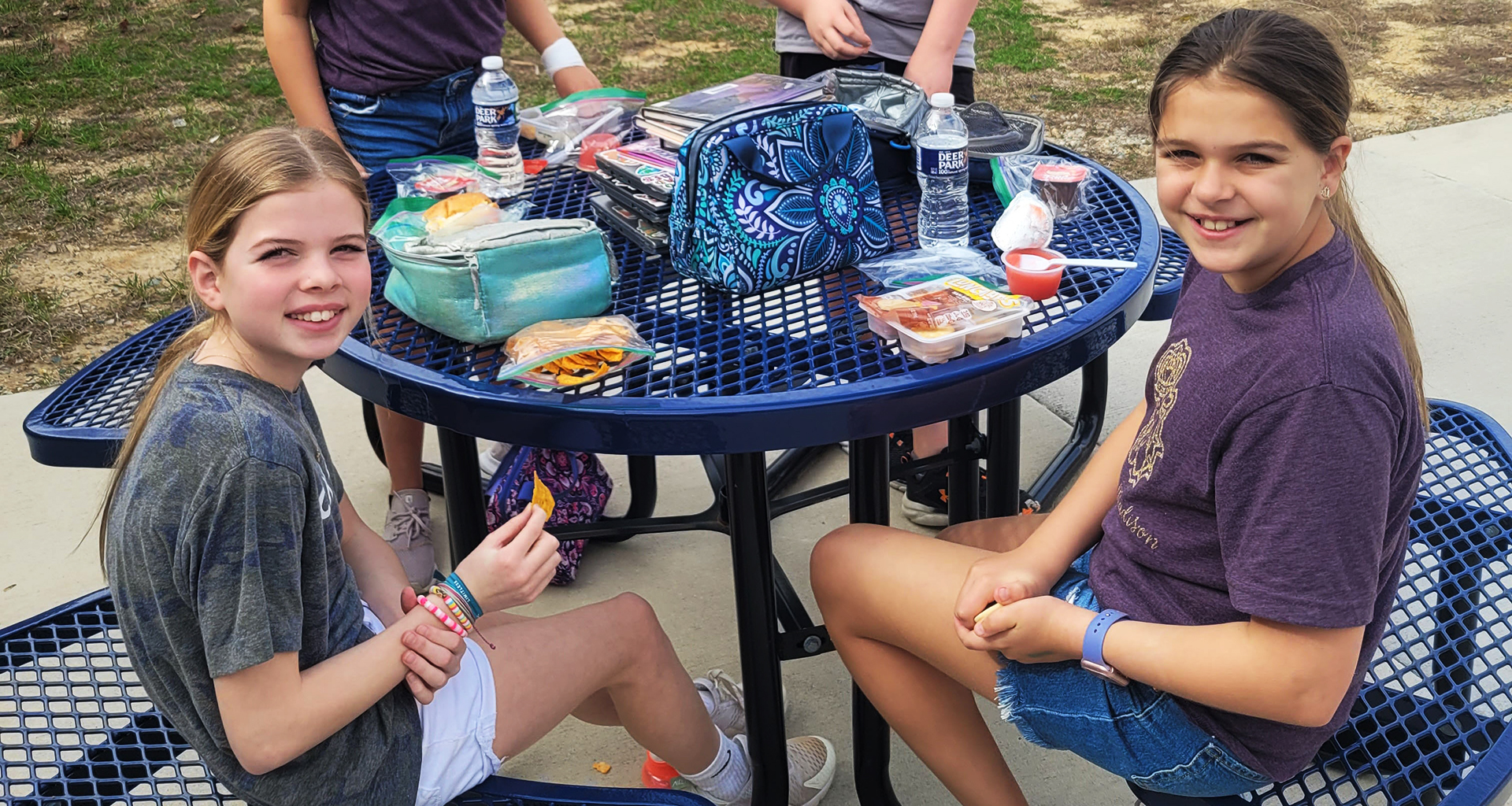 Students sitting outside eating their lunch.