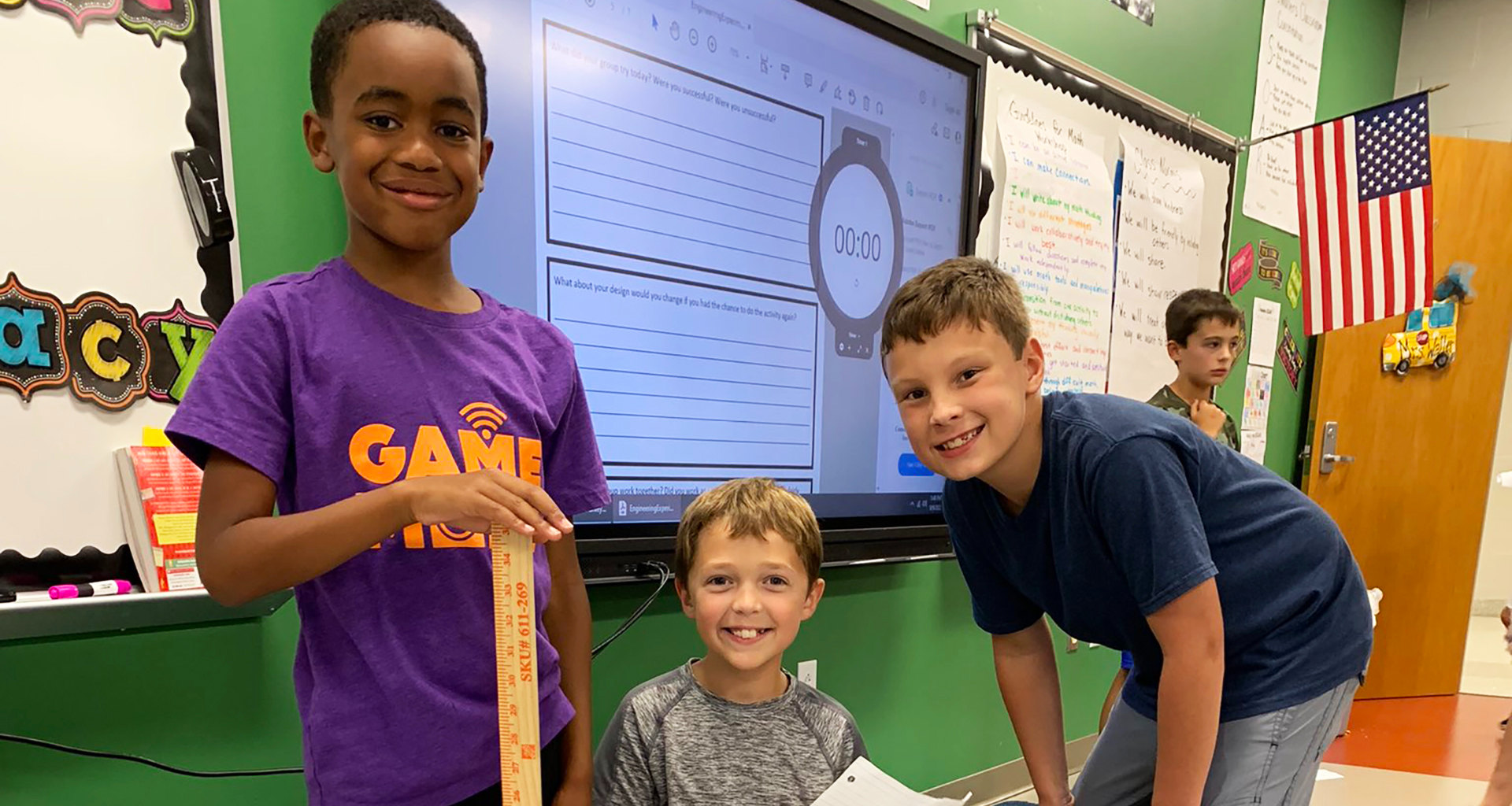 Three male students smile for the camera.