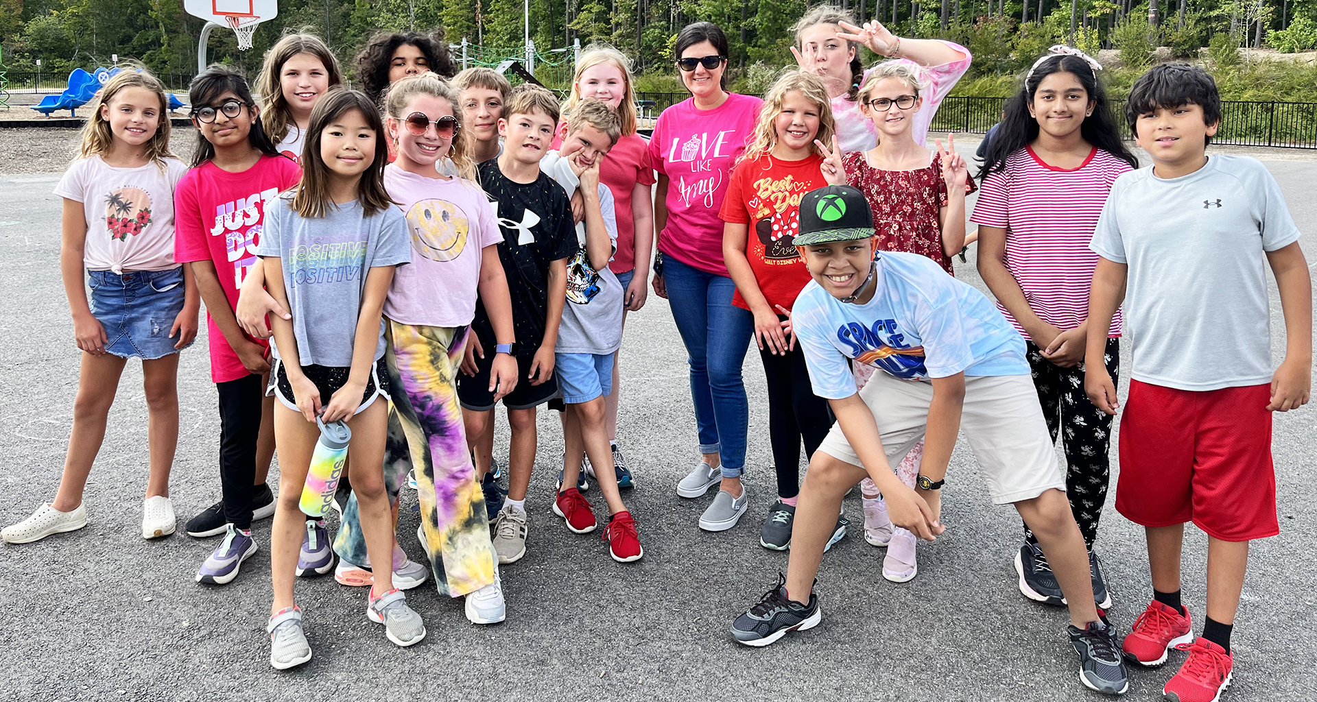 Large group of students pose for a group photo outside.