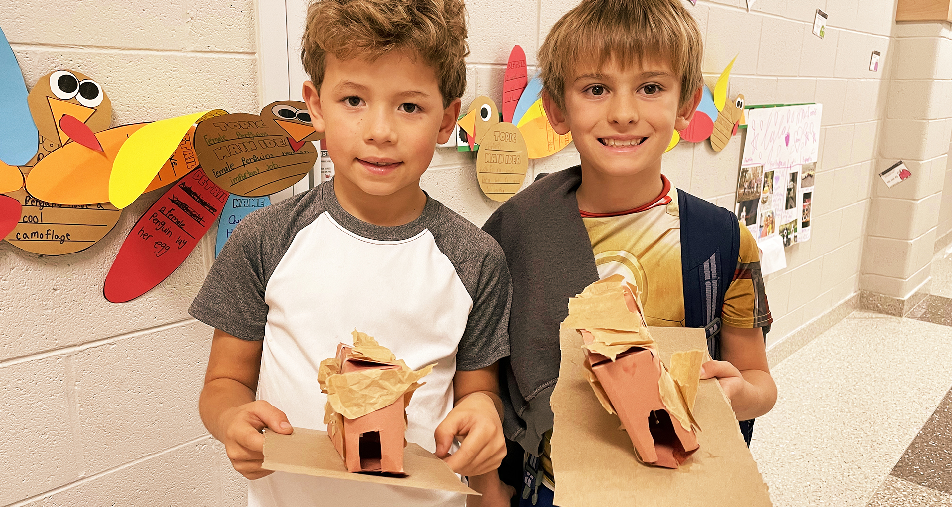 Two students holding up their projects.