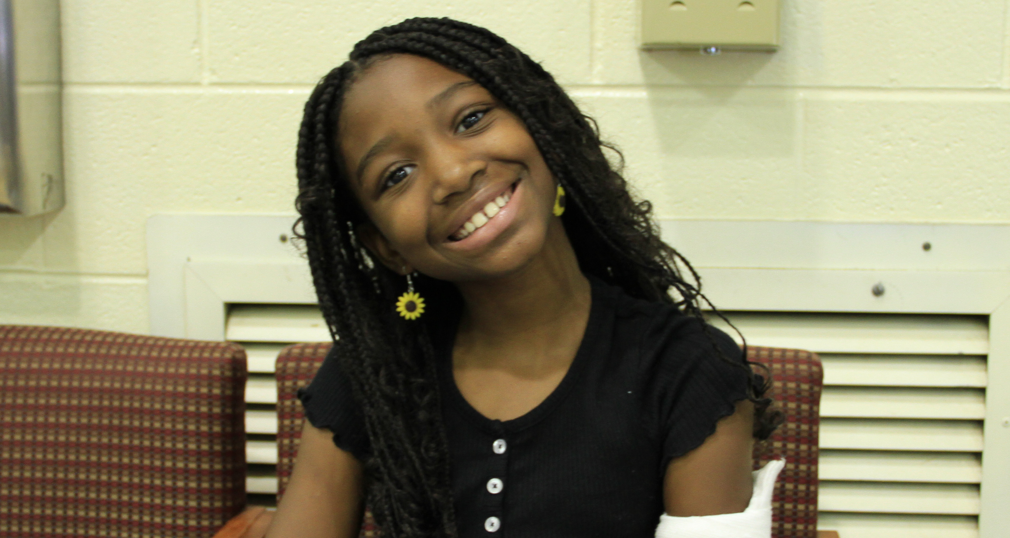 A girl smiling and sitting on a chair