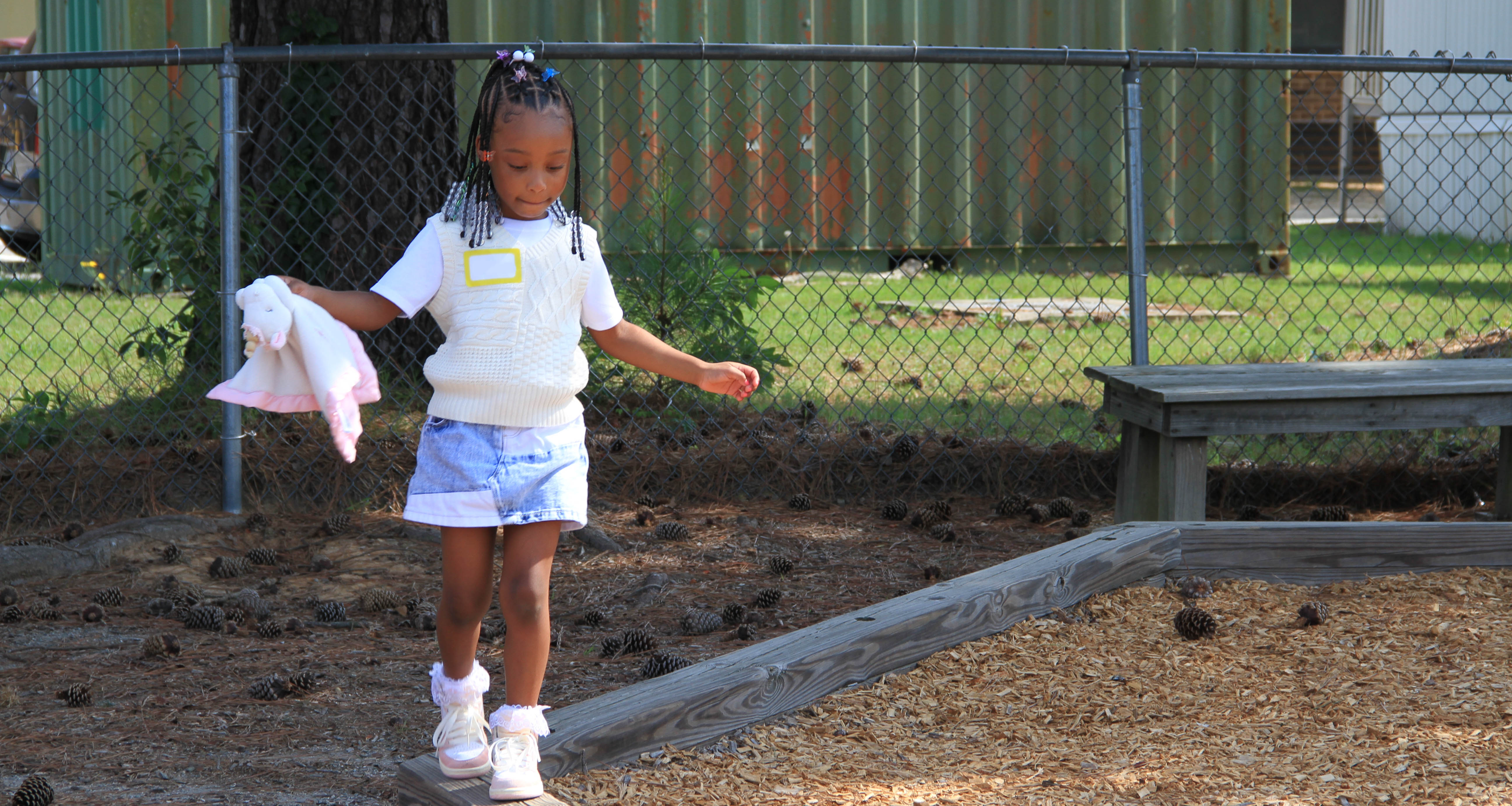 A girl walking on the edge of the school playground