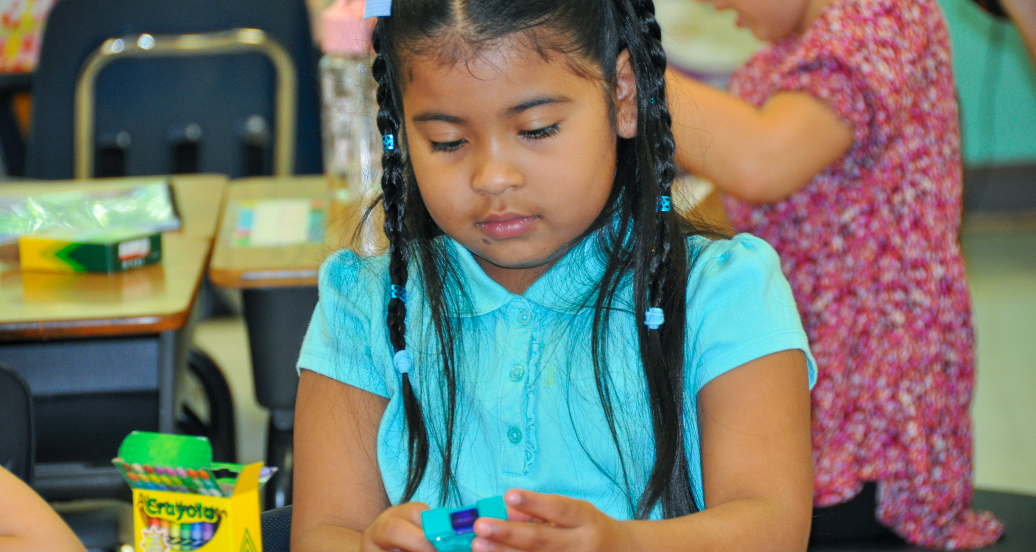 A girl playing with a plastic toy in class