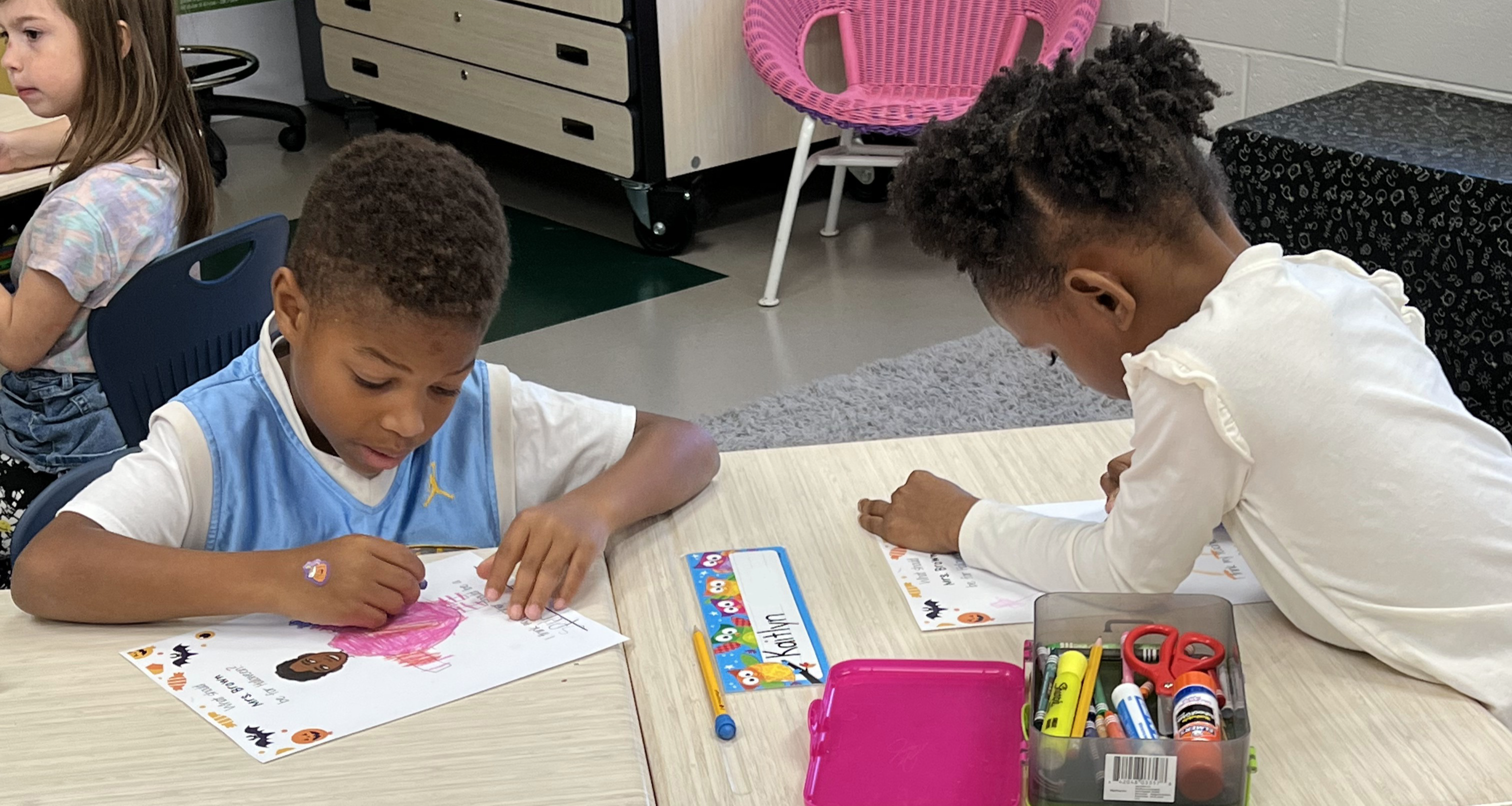 Two students coloring in class