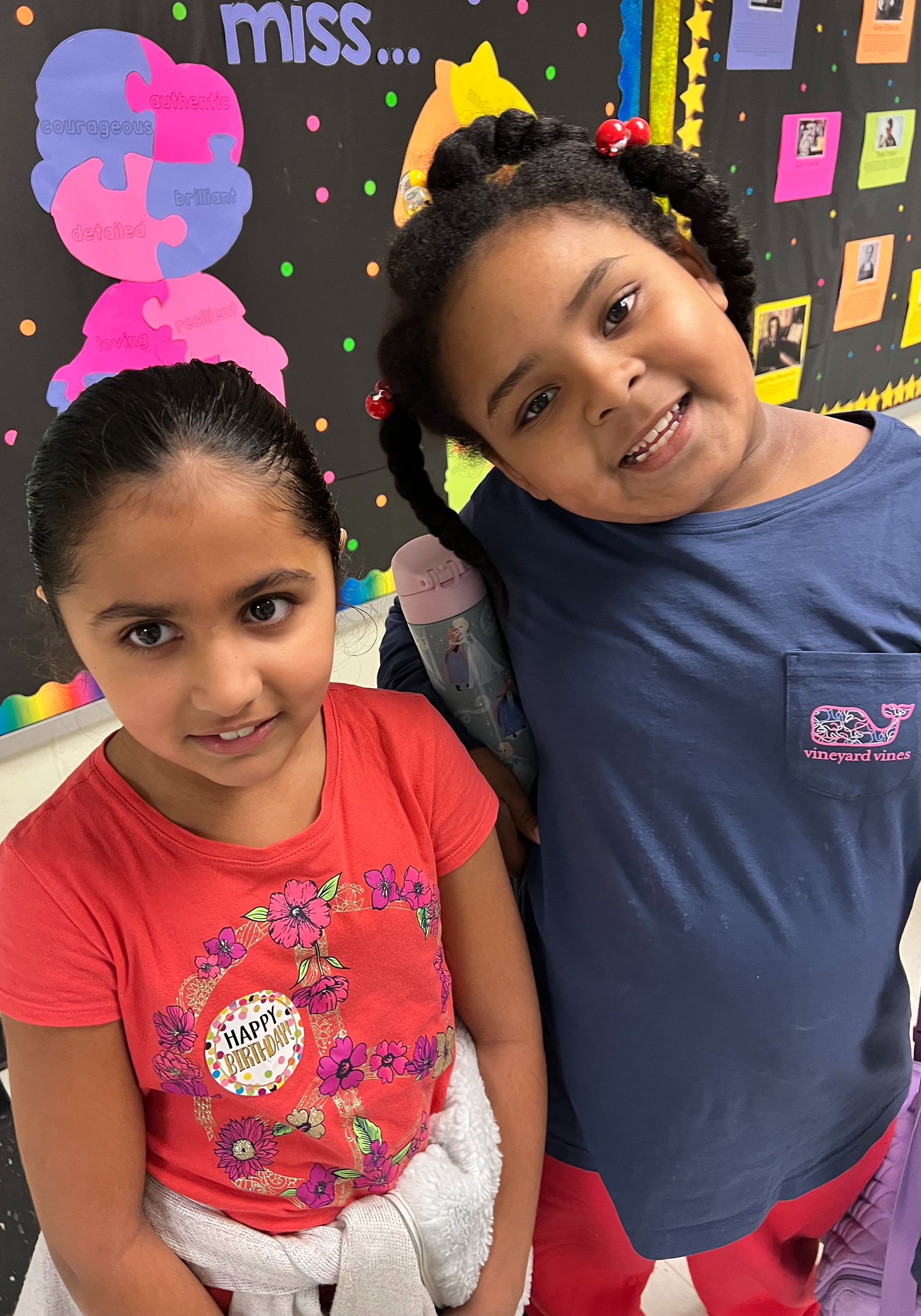Two female students smile for the camera.