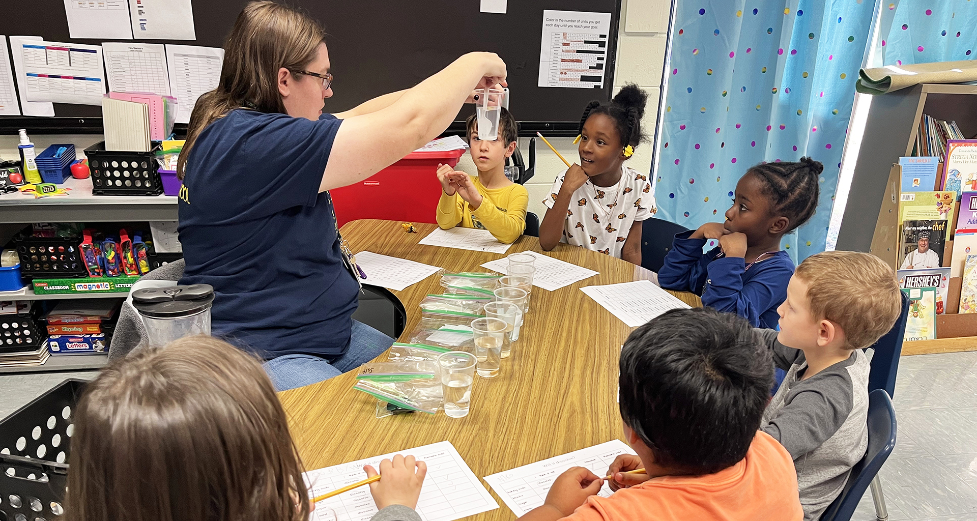 A teacher showing students a science experiment