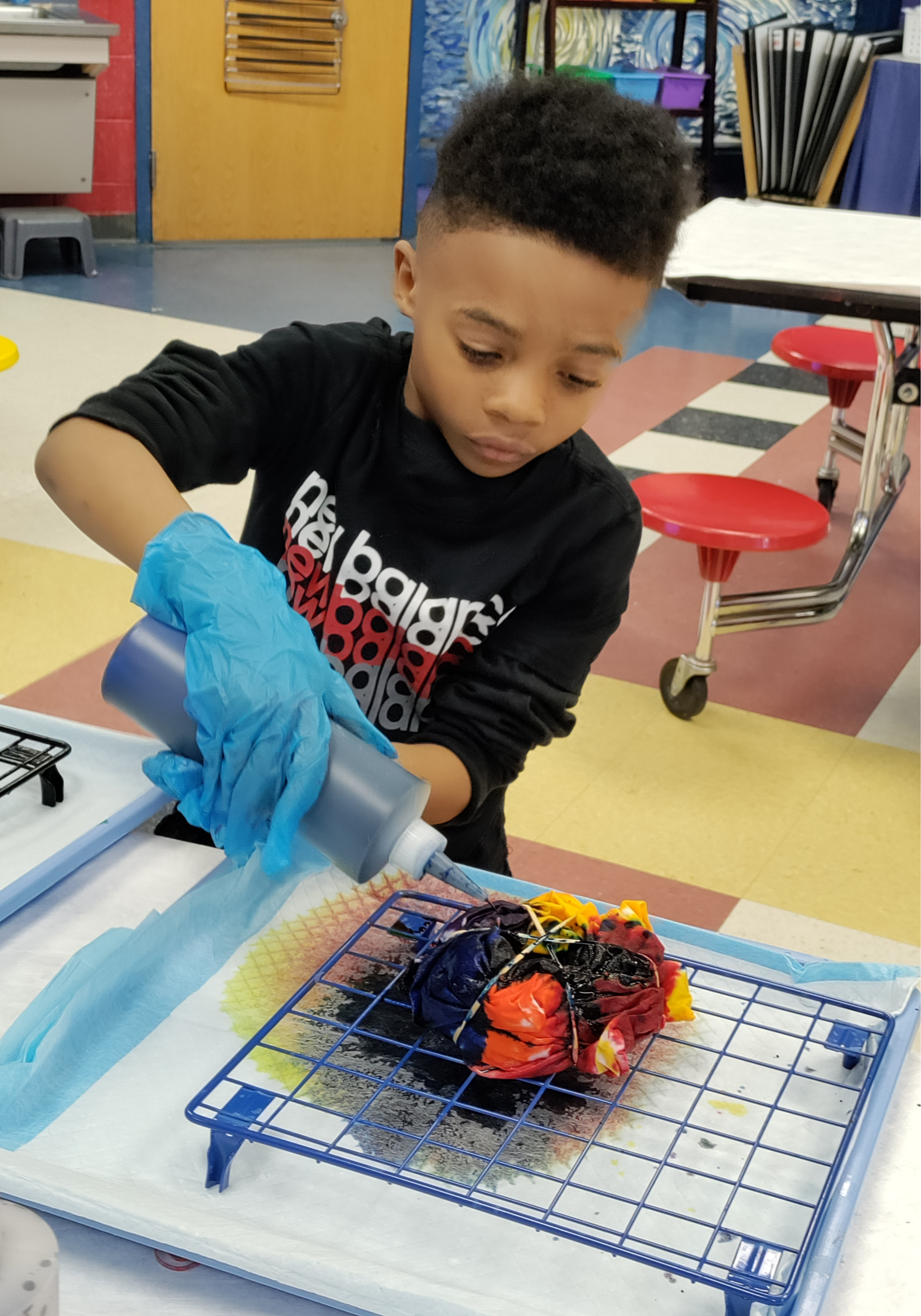 A student creating a tie dye shirt in class