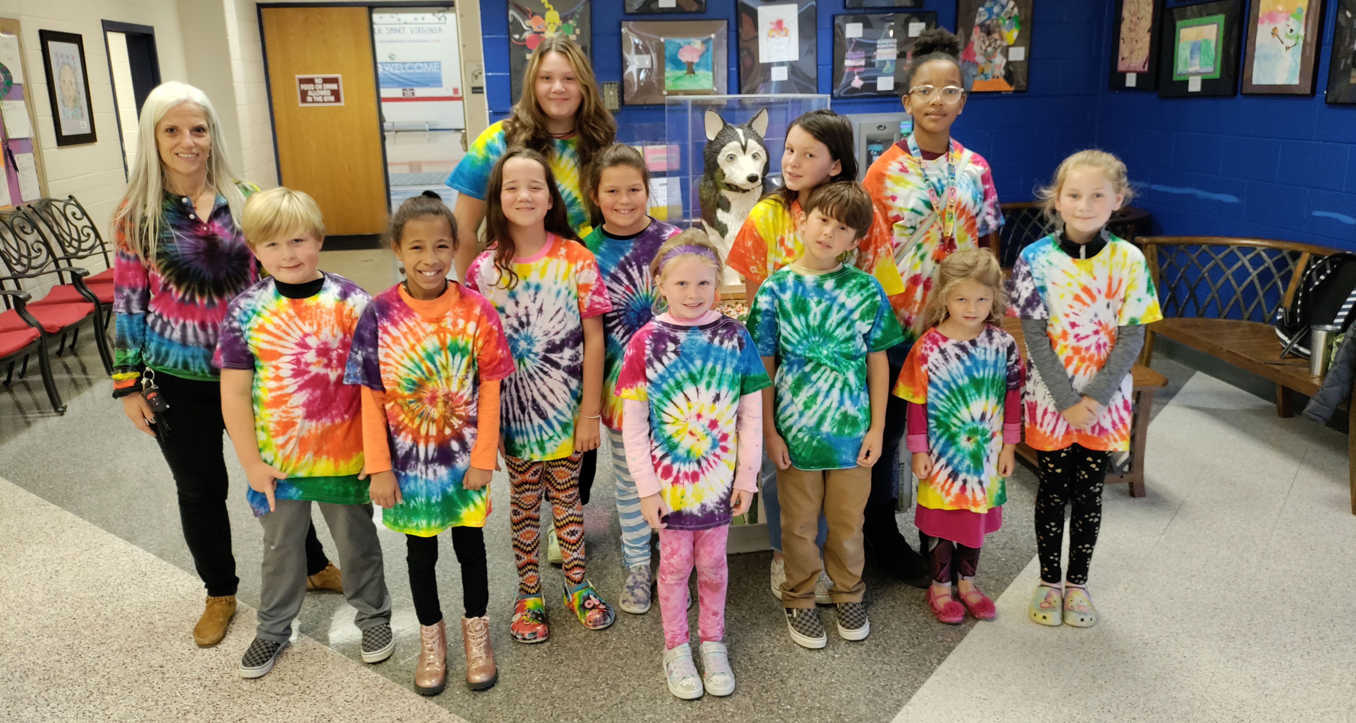 A large group of students and some staff wearing tie dye shirts