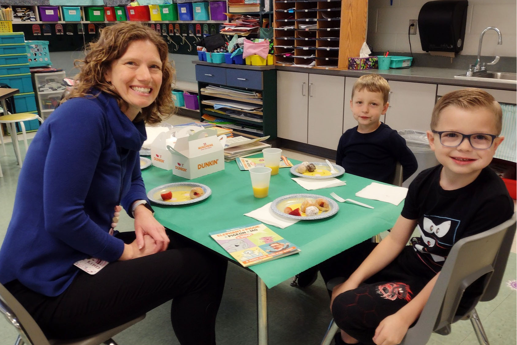 Teacher with two boys having breakfast